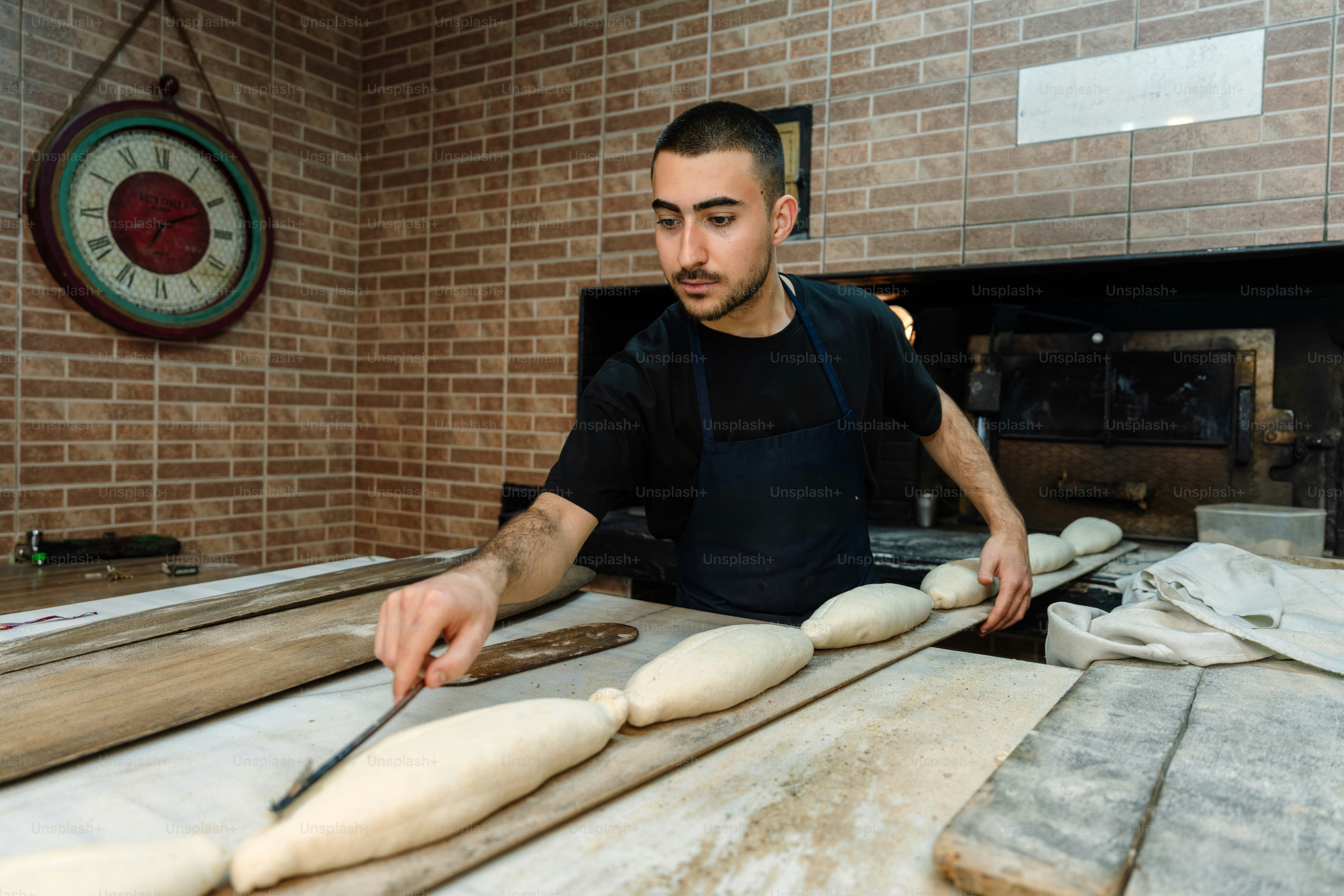 A baker shaping dough in a traditional bakery.