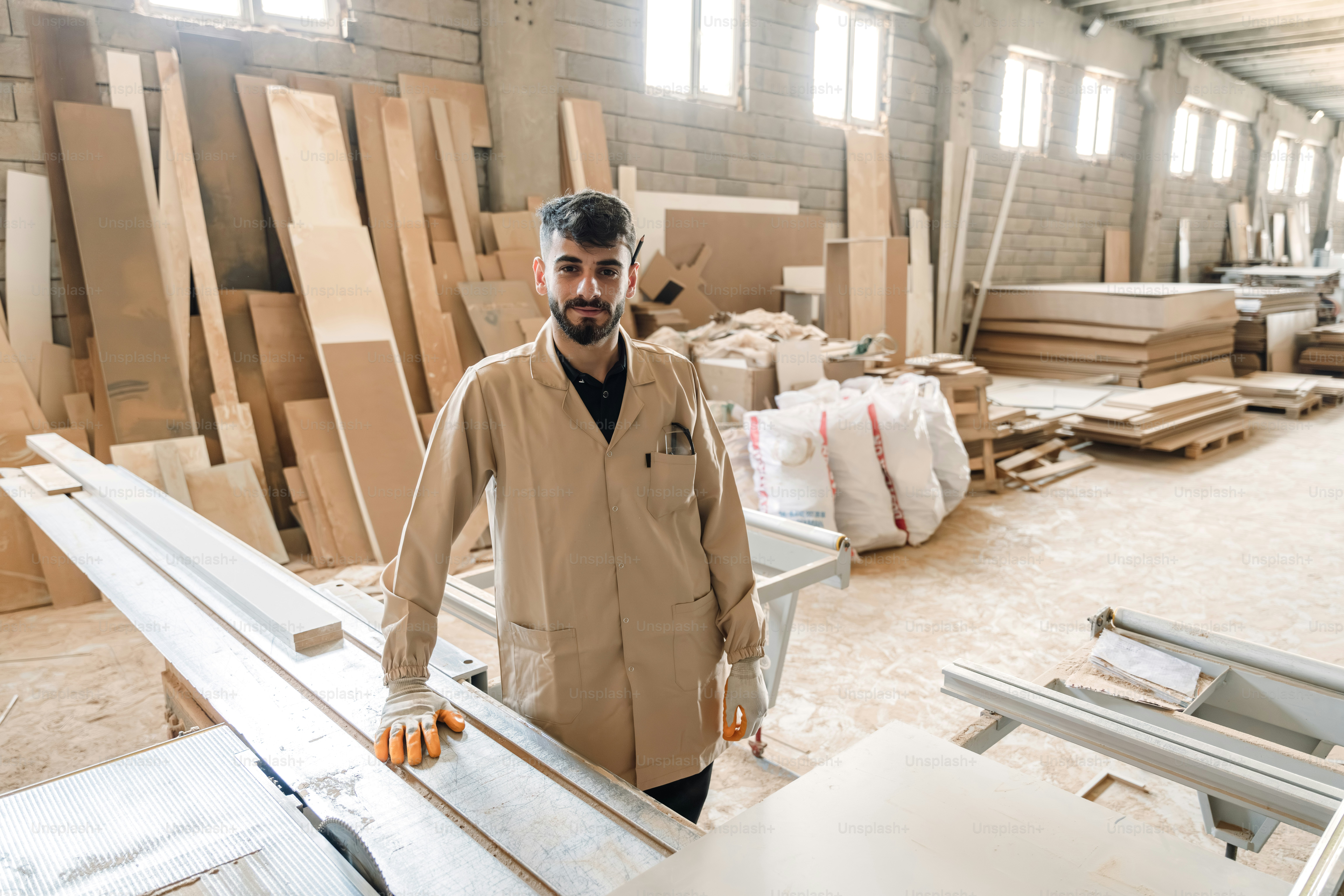 Woodworker in a workshop surrounded by lumber and machinery.