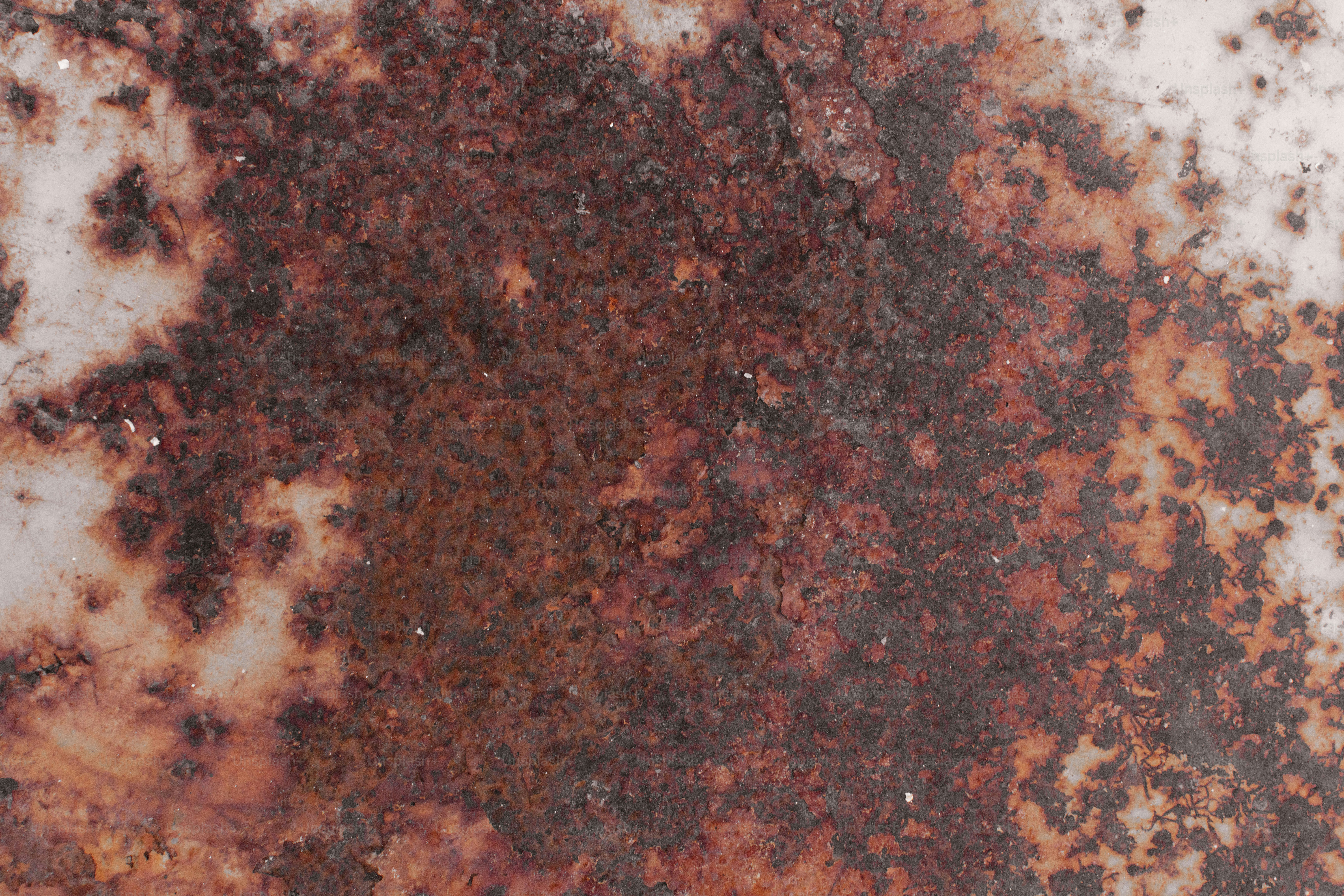 Permukaan lapuk dengan karat coklat tua dan perubahan warna putih.
