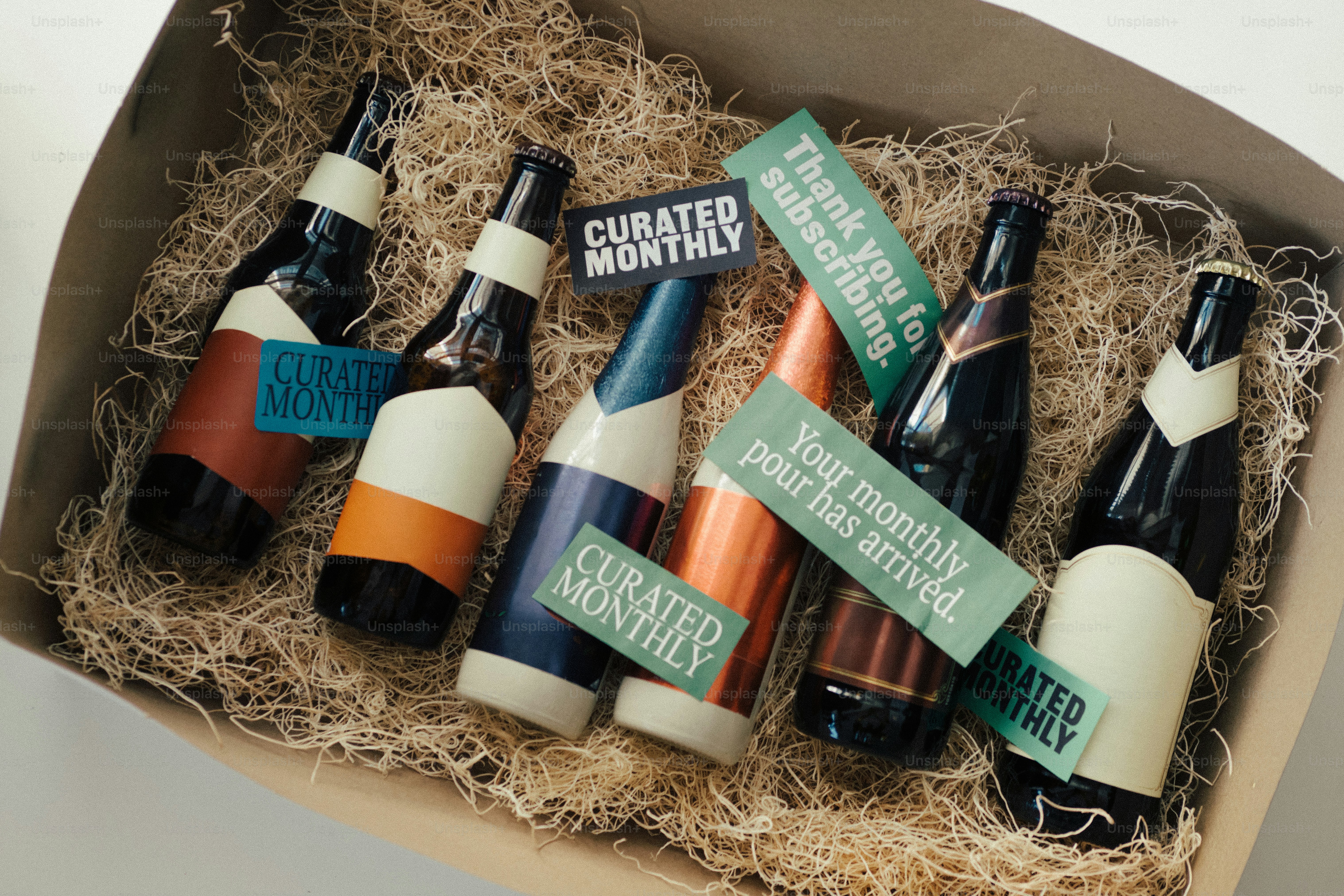 Caja de suscripción mensual seleccionada con seis botellas y material de embalaje.