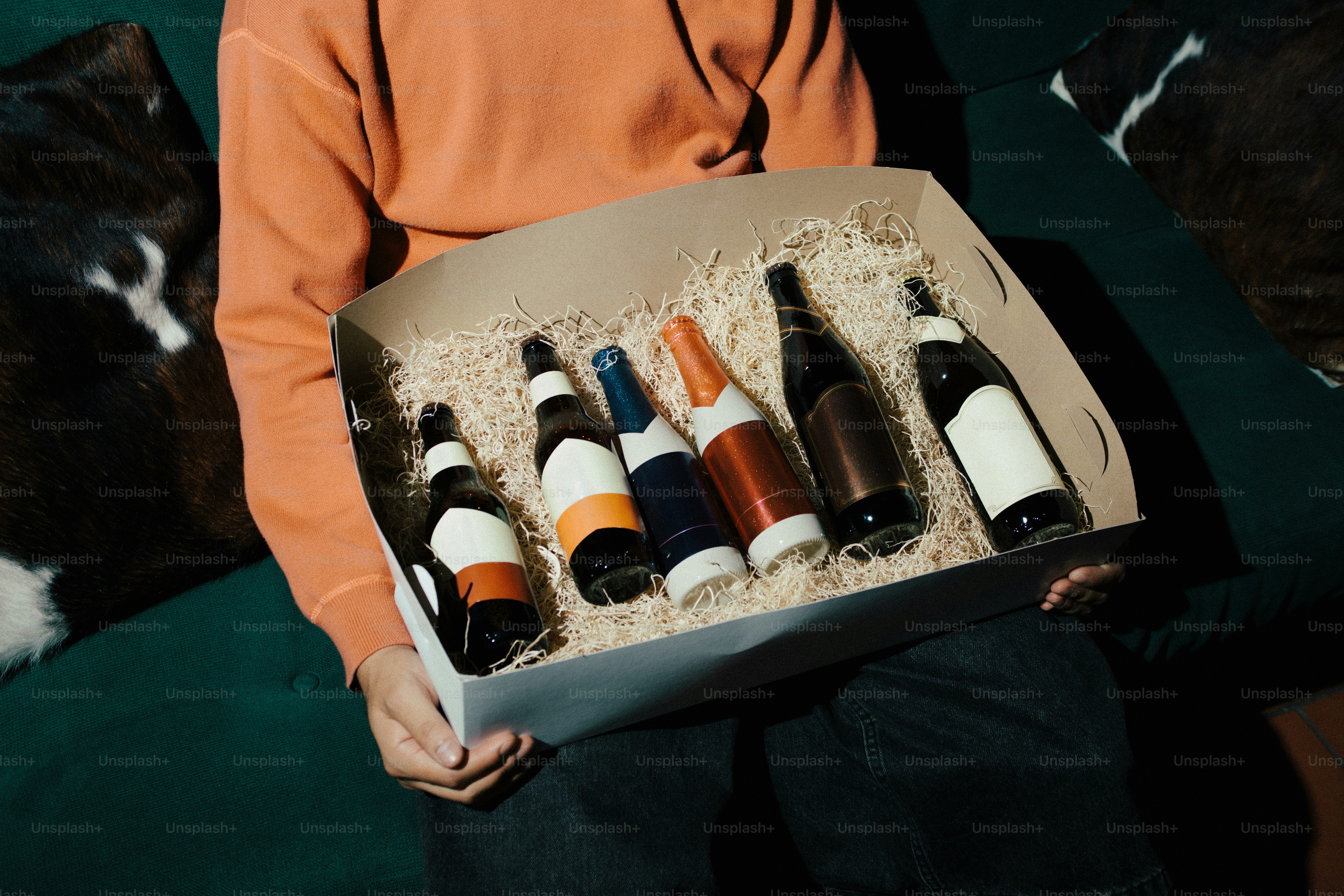 Persona sosteniendo una caja de regalo con varias botellas.