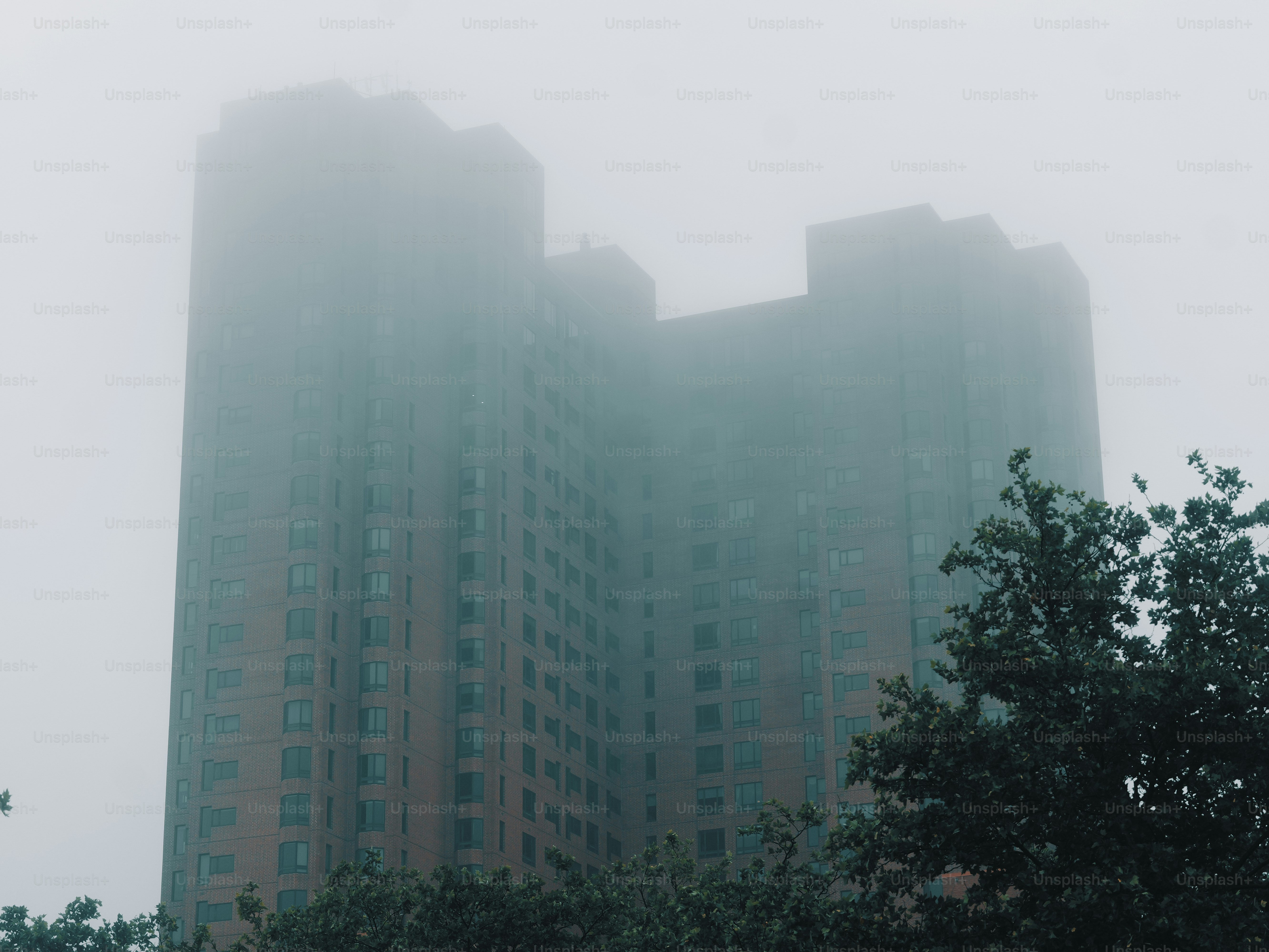 A tall building shrouded in dense fog.