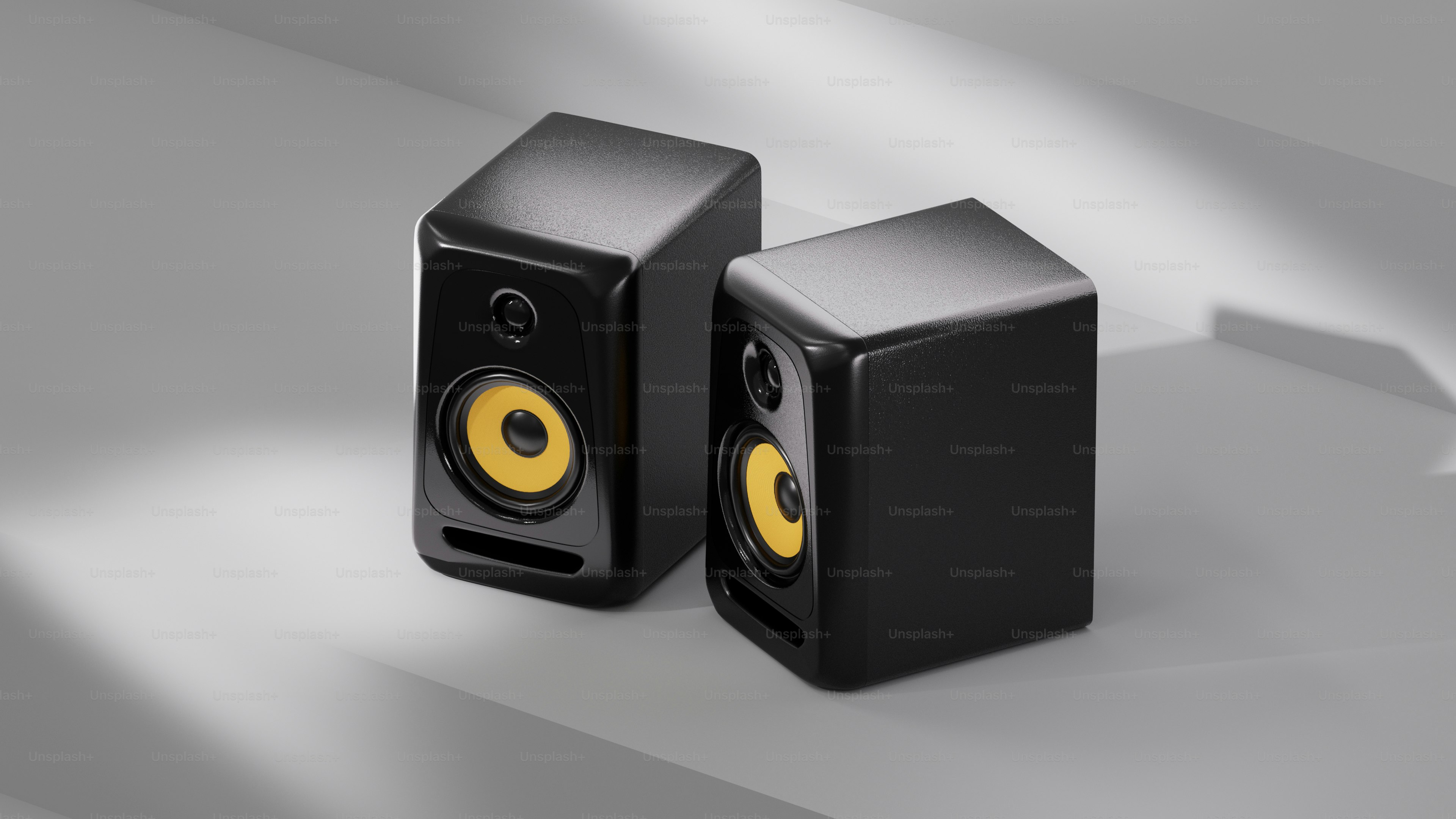 Speaker monitor studio hitam dengan kerucut kuning.