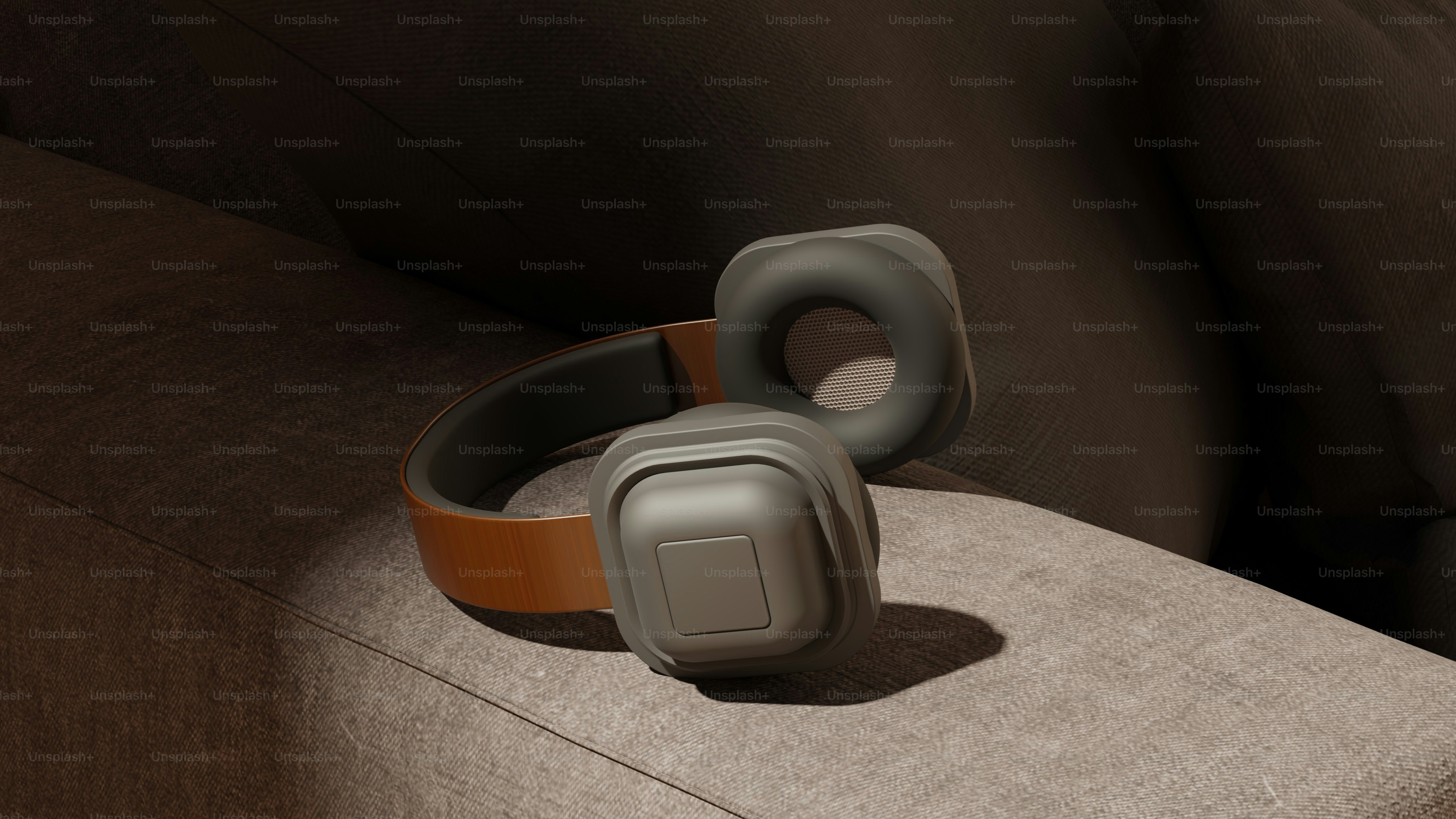 Auriculares grises y marrones en un sofá texturizado.