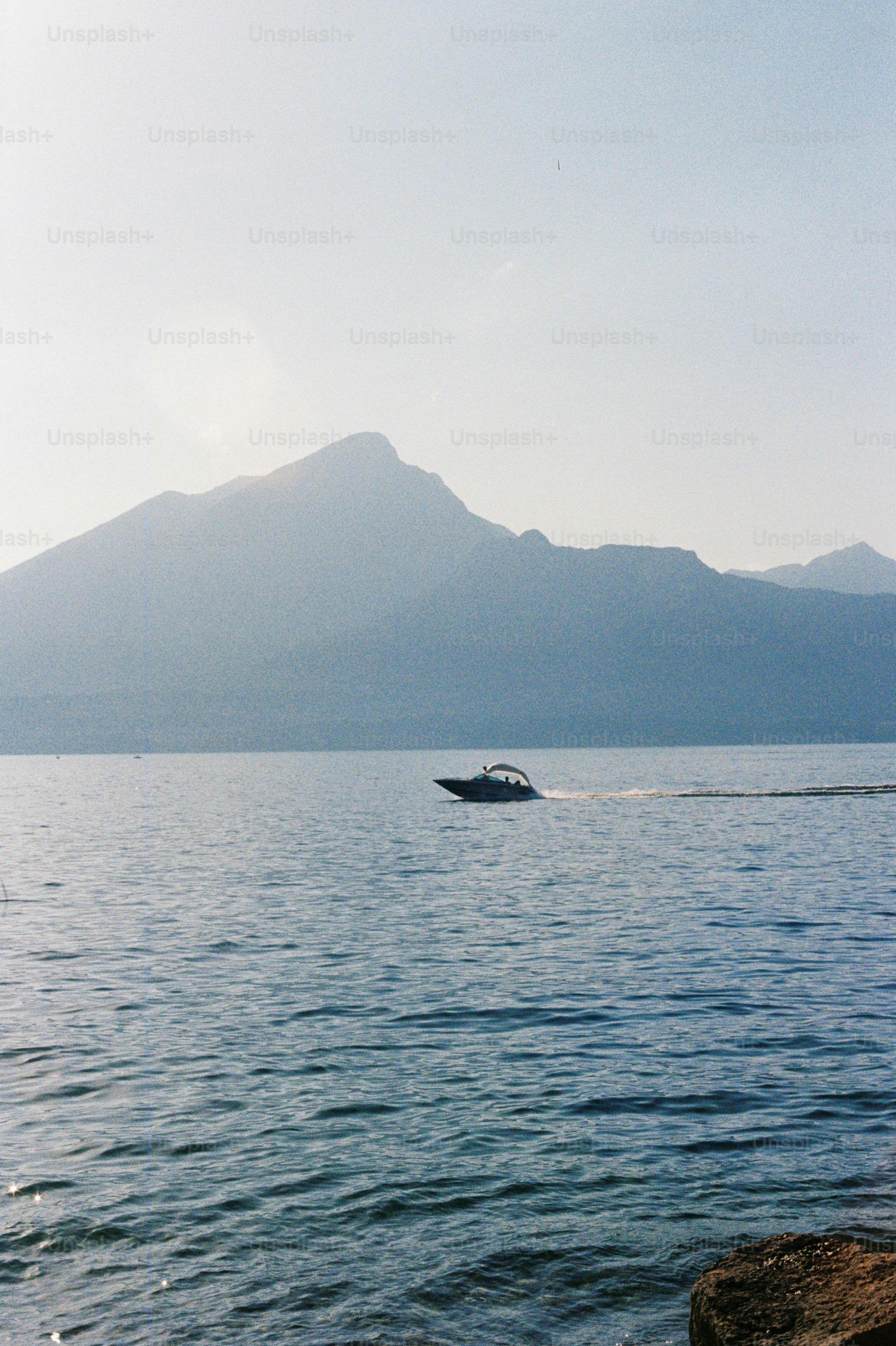 Perahu di danau dengan pegunungan berkabut.