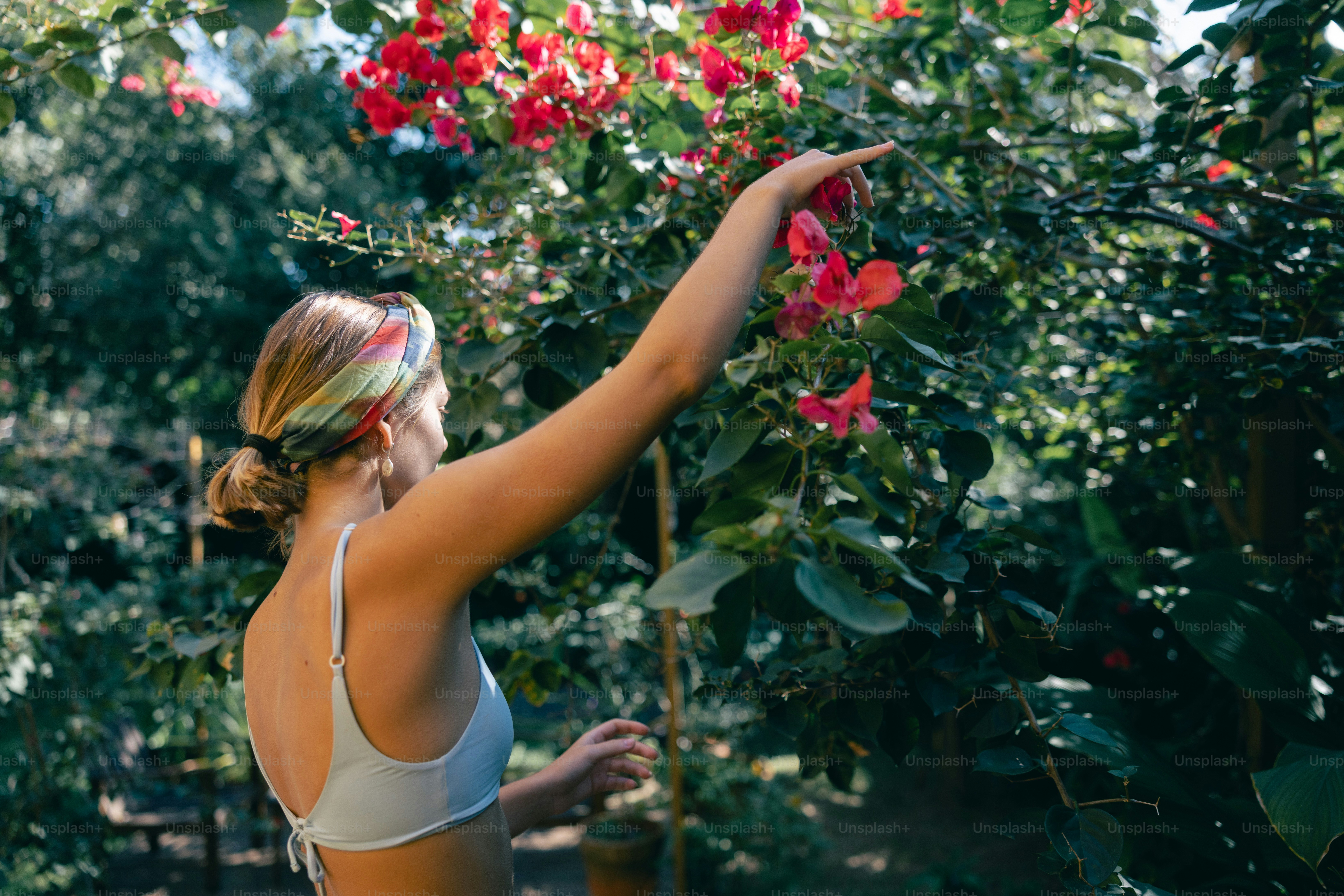 Donna che cerca fiori rossi in fiore all'aperto