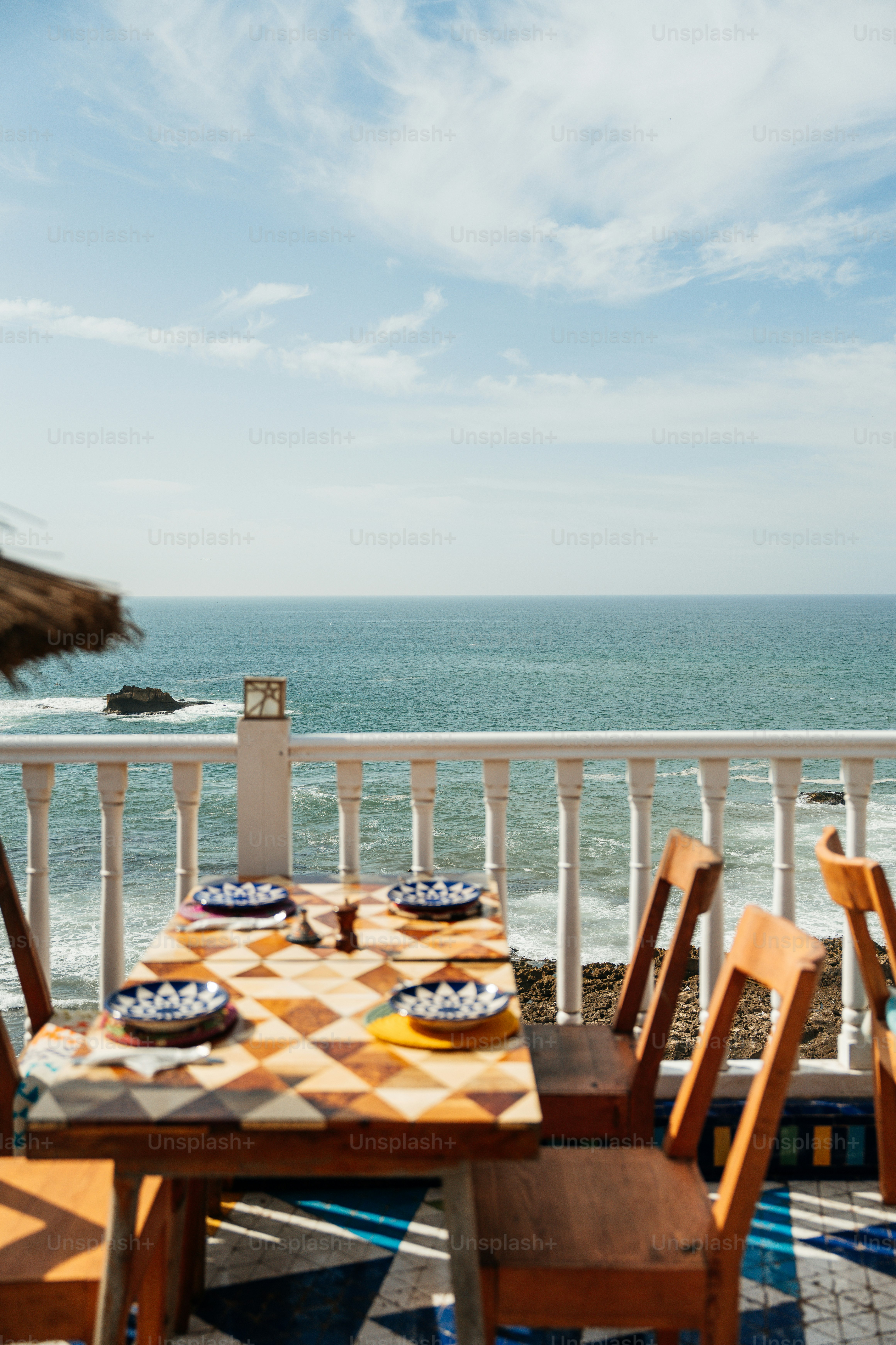 Scenic outdoor dining table overlooking the vast blue ocean. photo ...