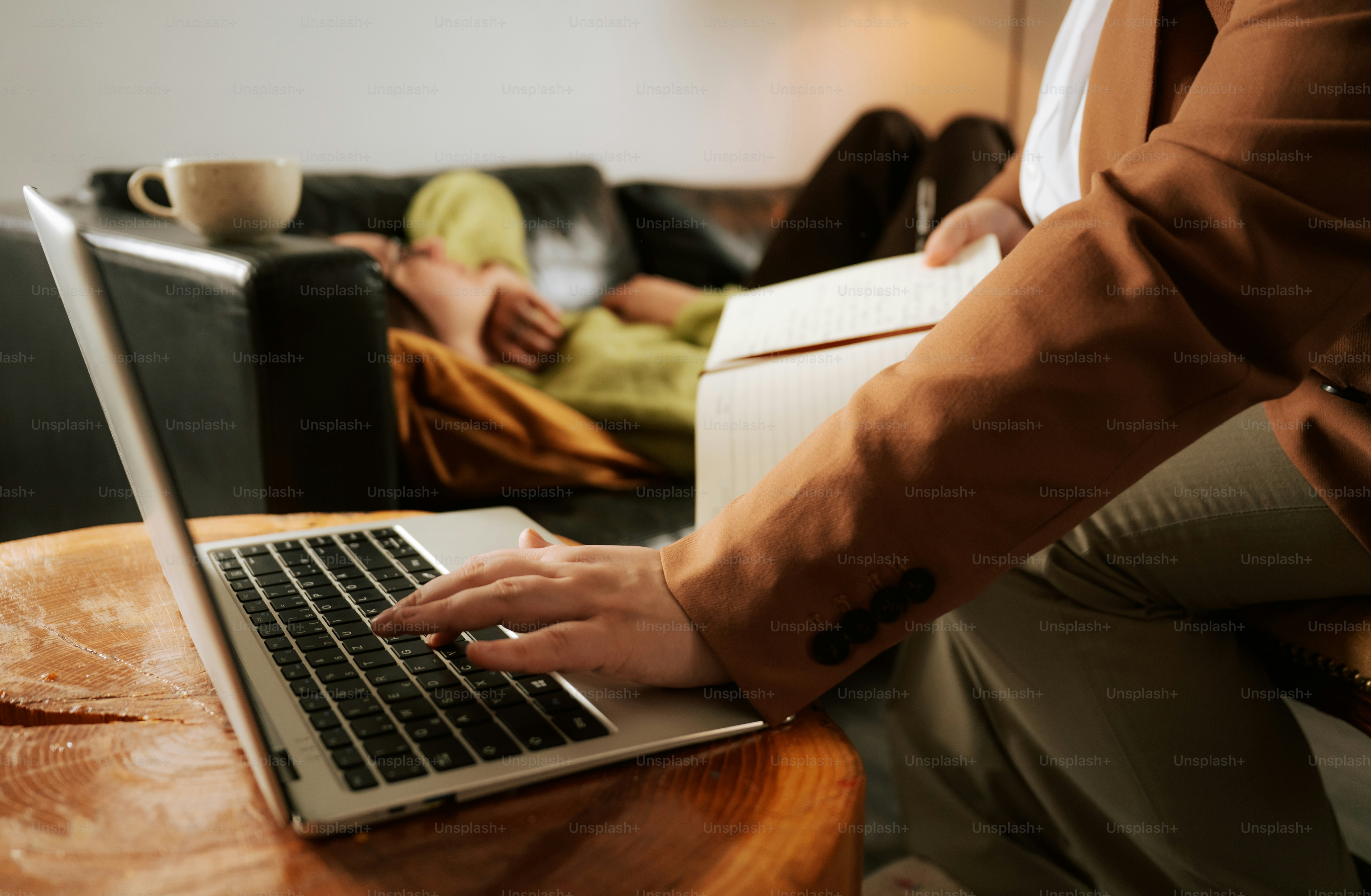Man works on laptop, woman relaxes on couch.