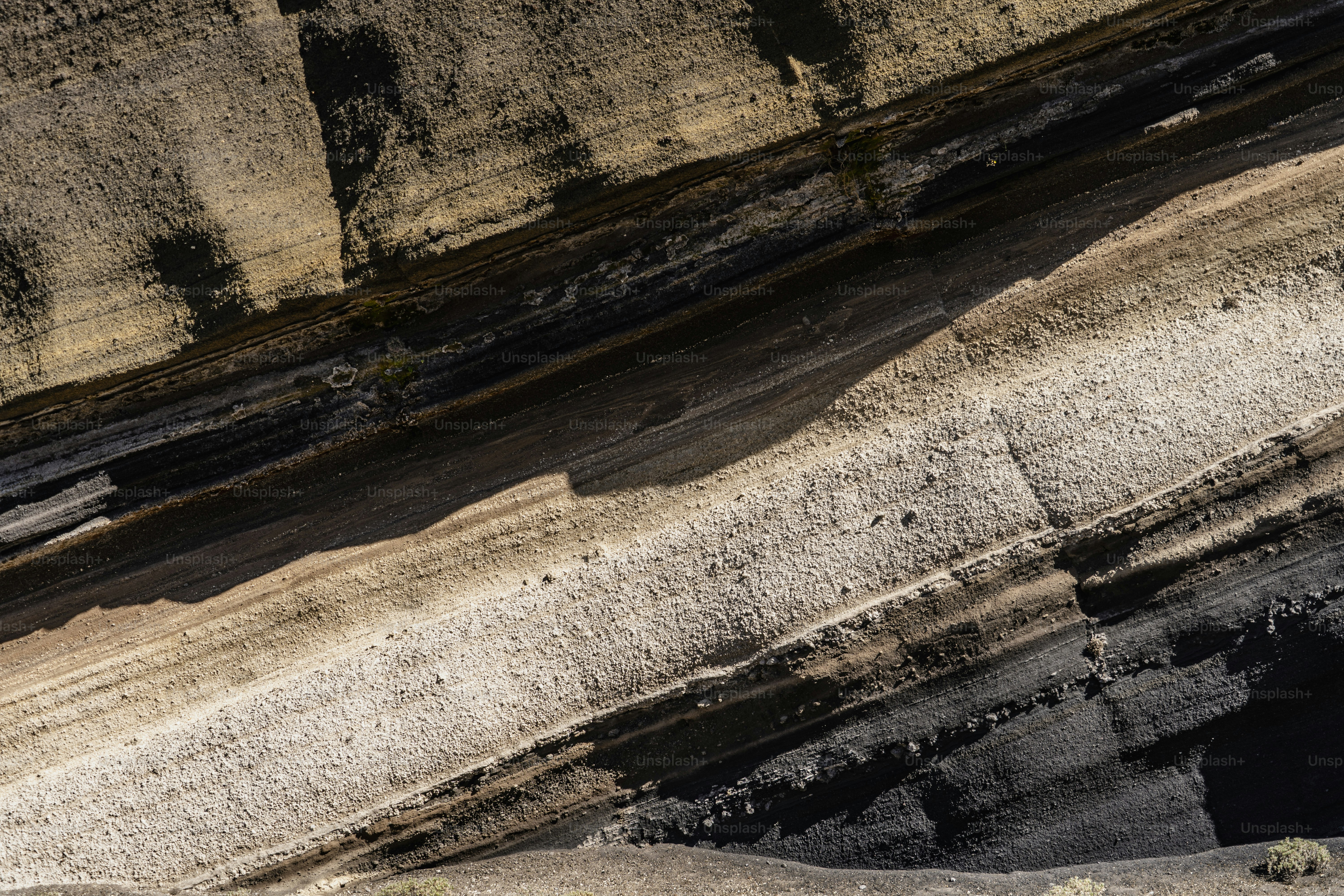 Abstract layers of black, brown, and white rock formations.