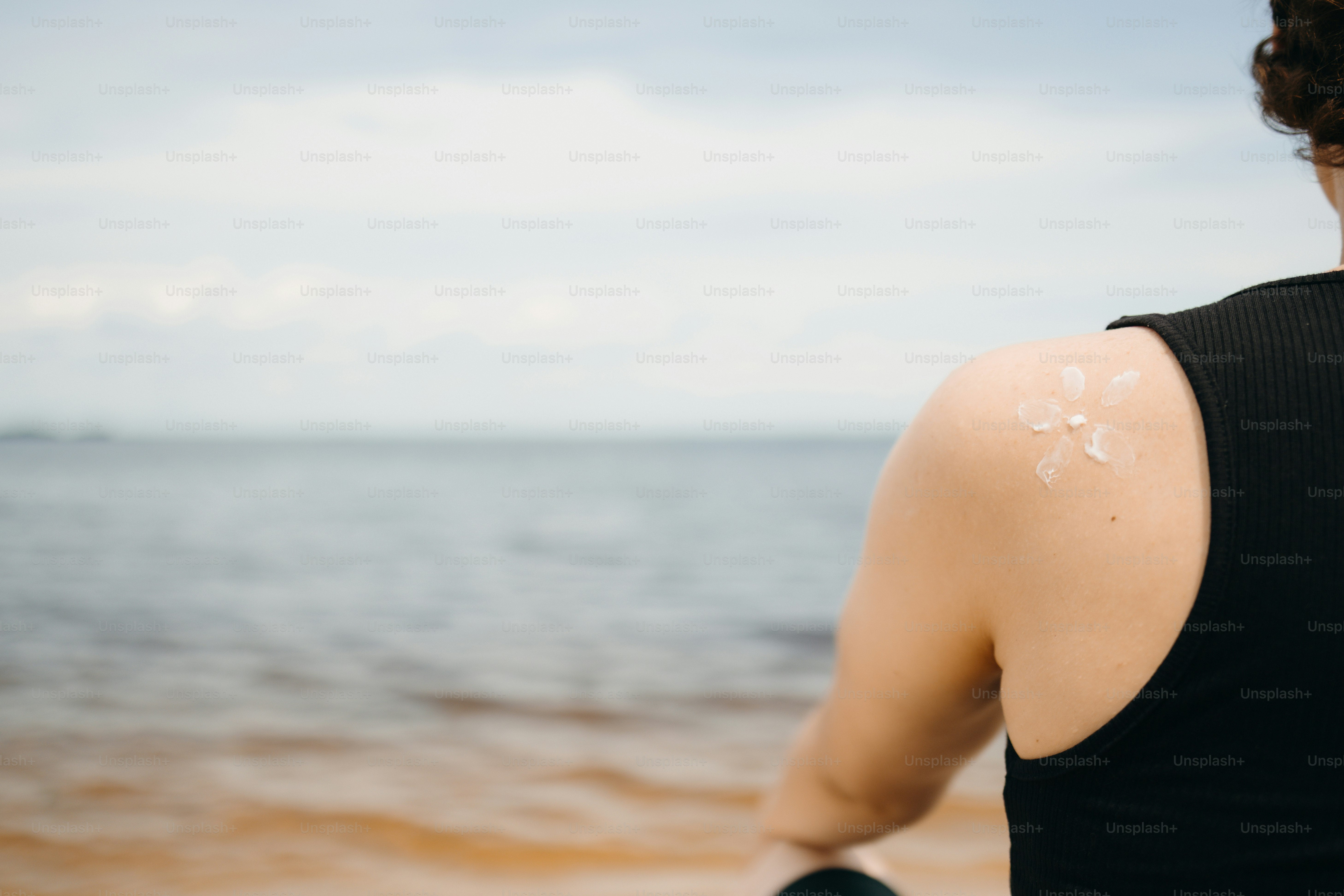 Sunscreen on a person's shoulder by the water.