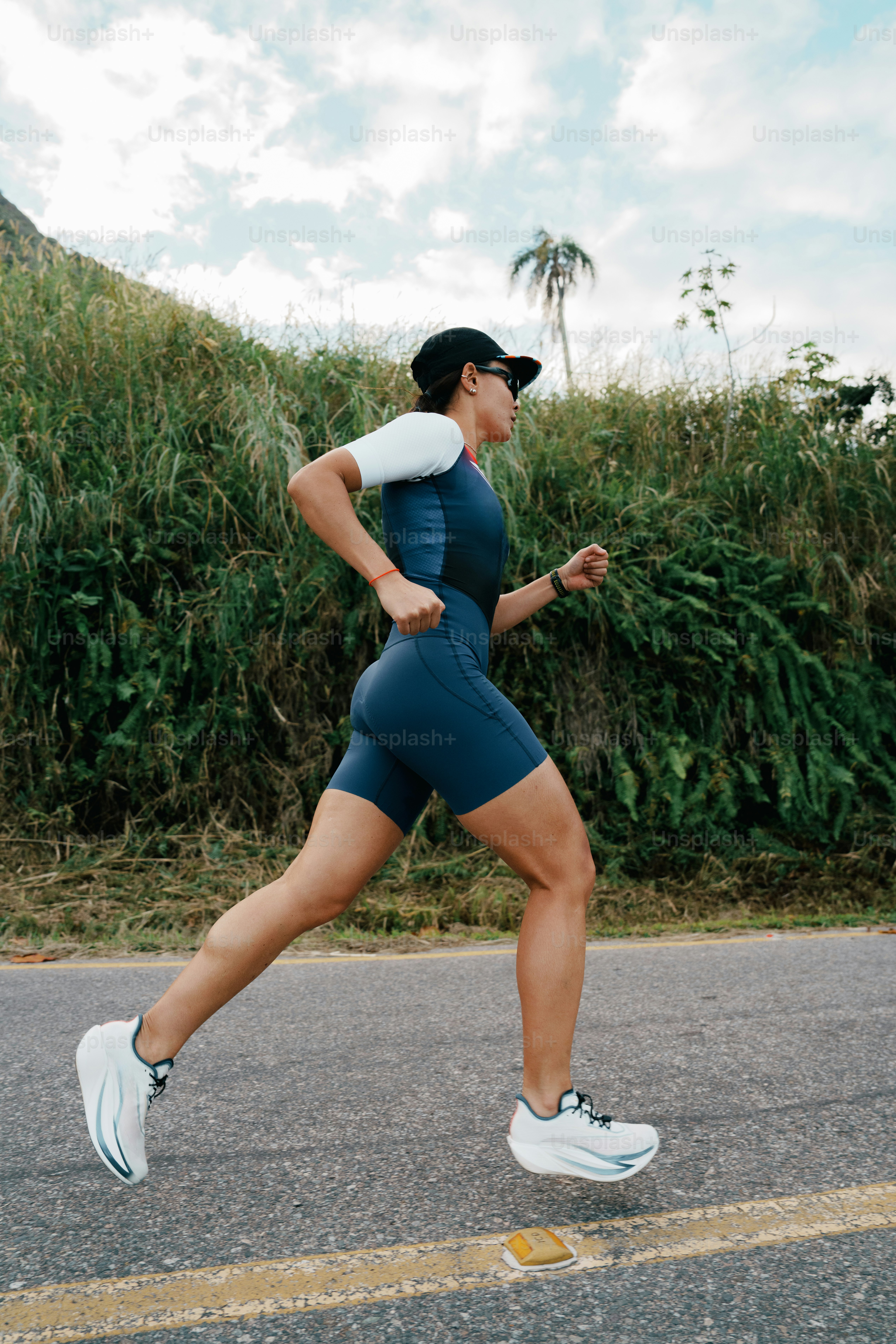A woman runs on a road with green foliage