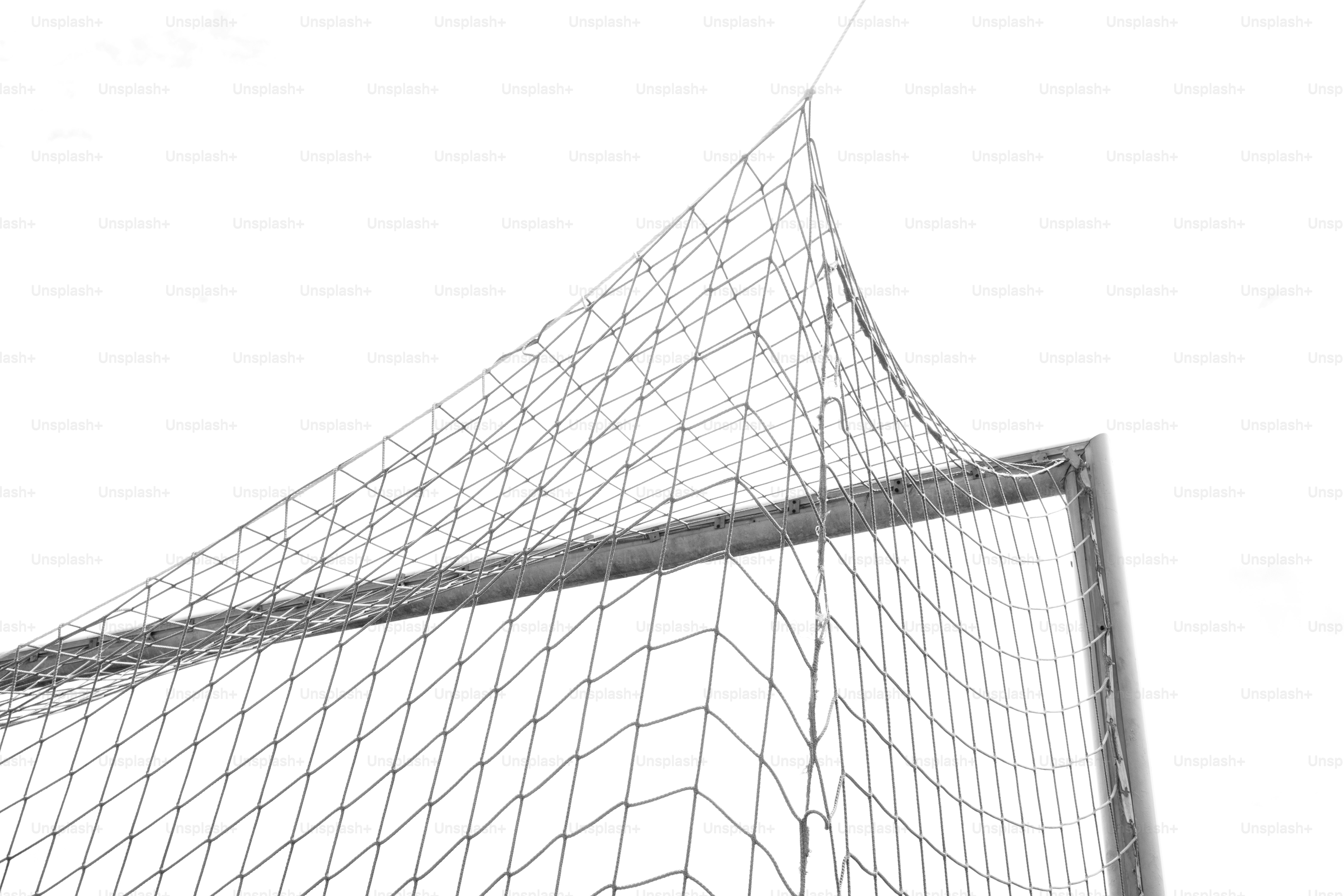 A soccer goal net and frame against a white sky.