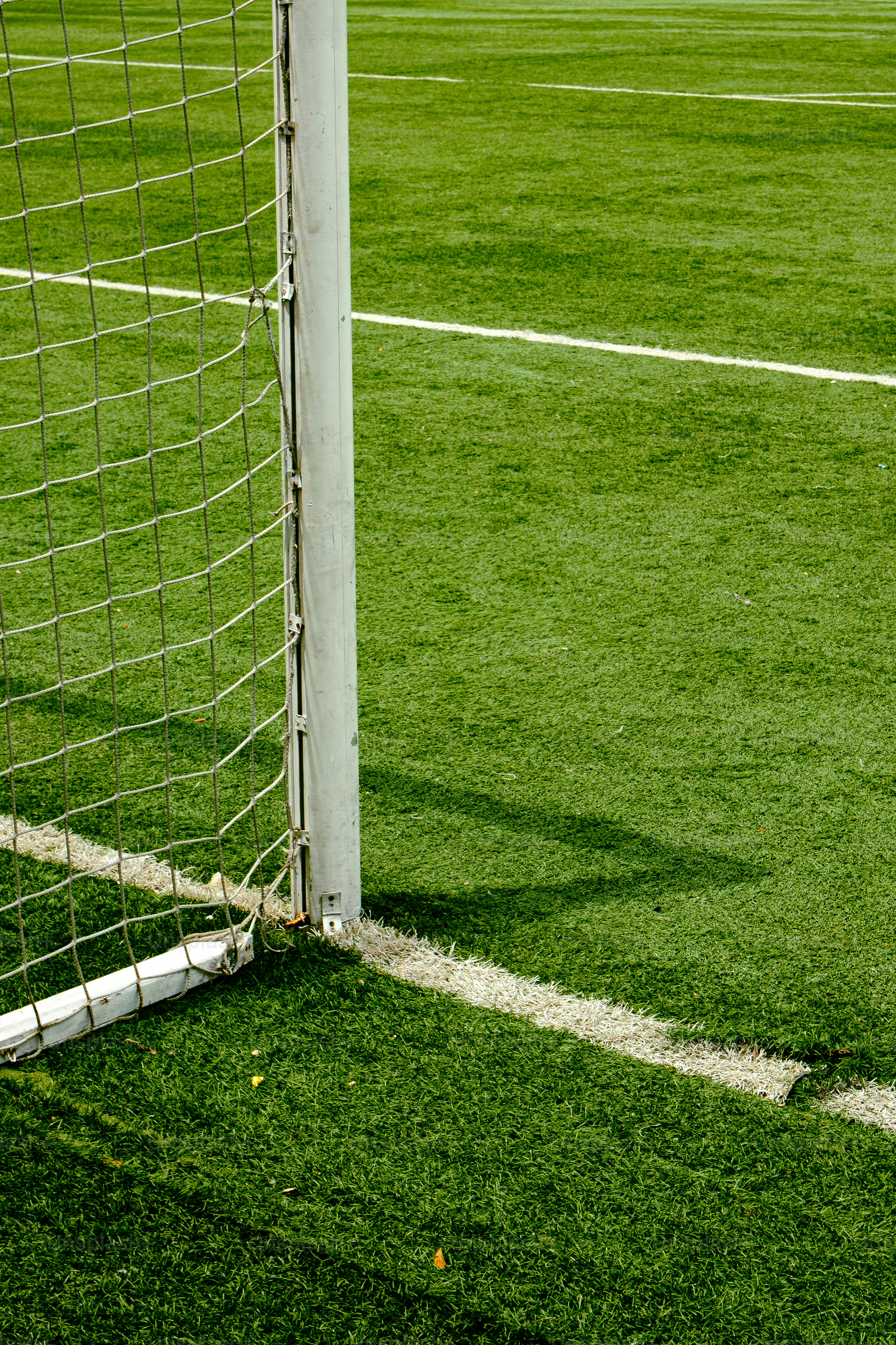 A soccer goal post and net on a green field.