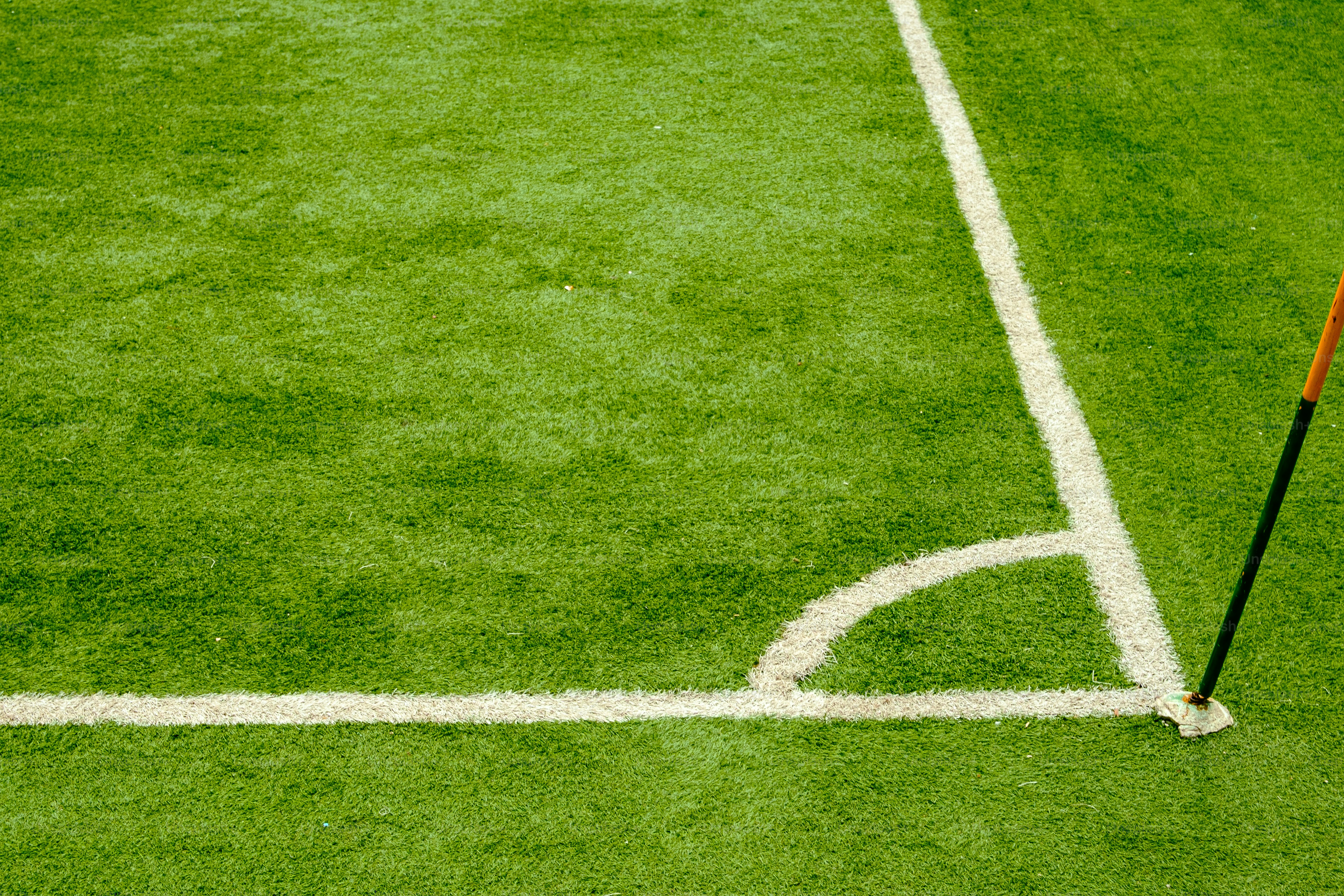 A soccer field corner with white lines and a flag.