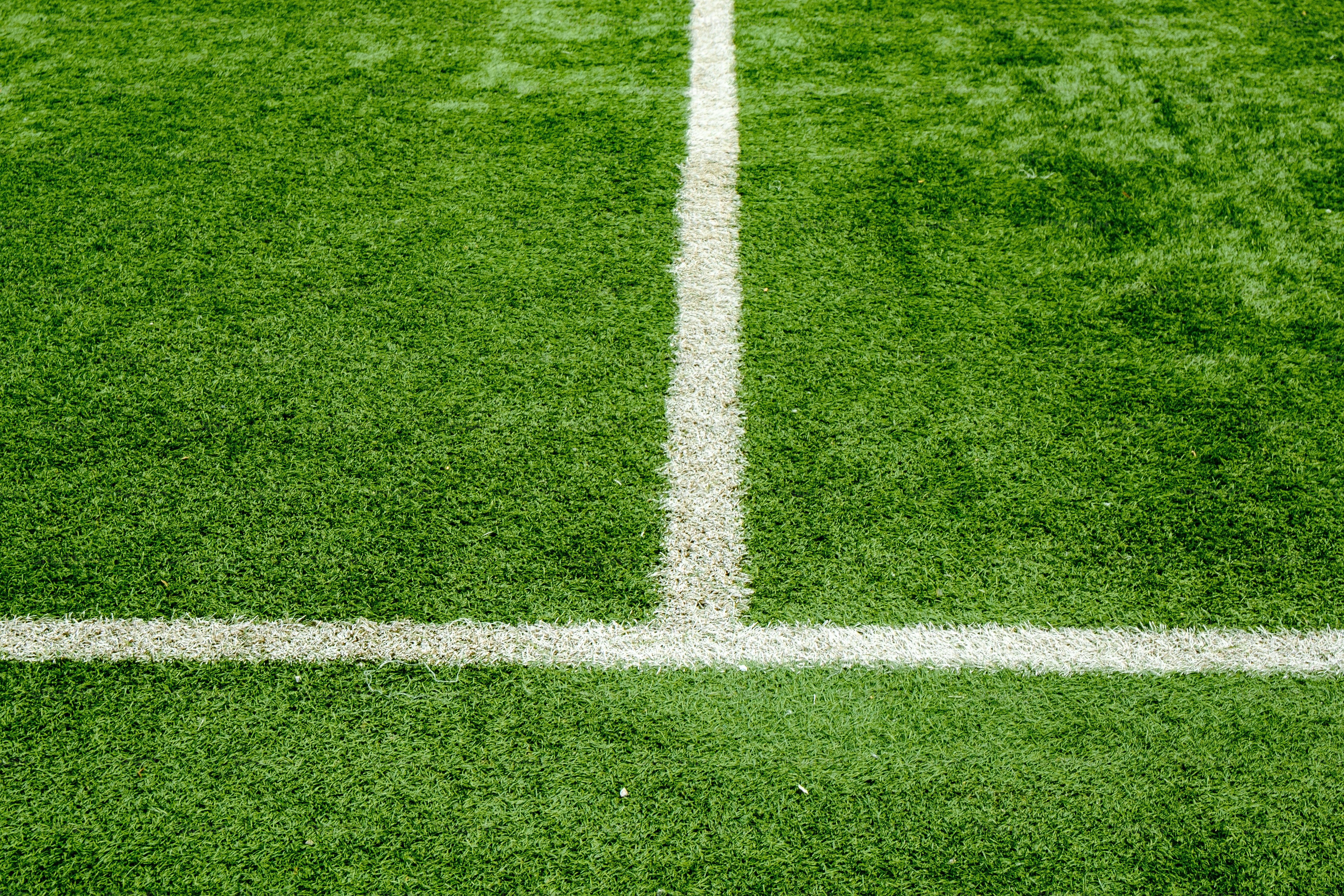Green artificial turf with white lines for sports.
