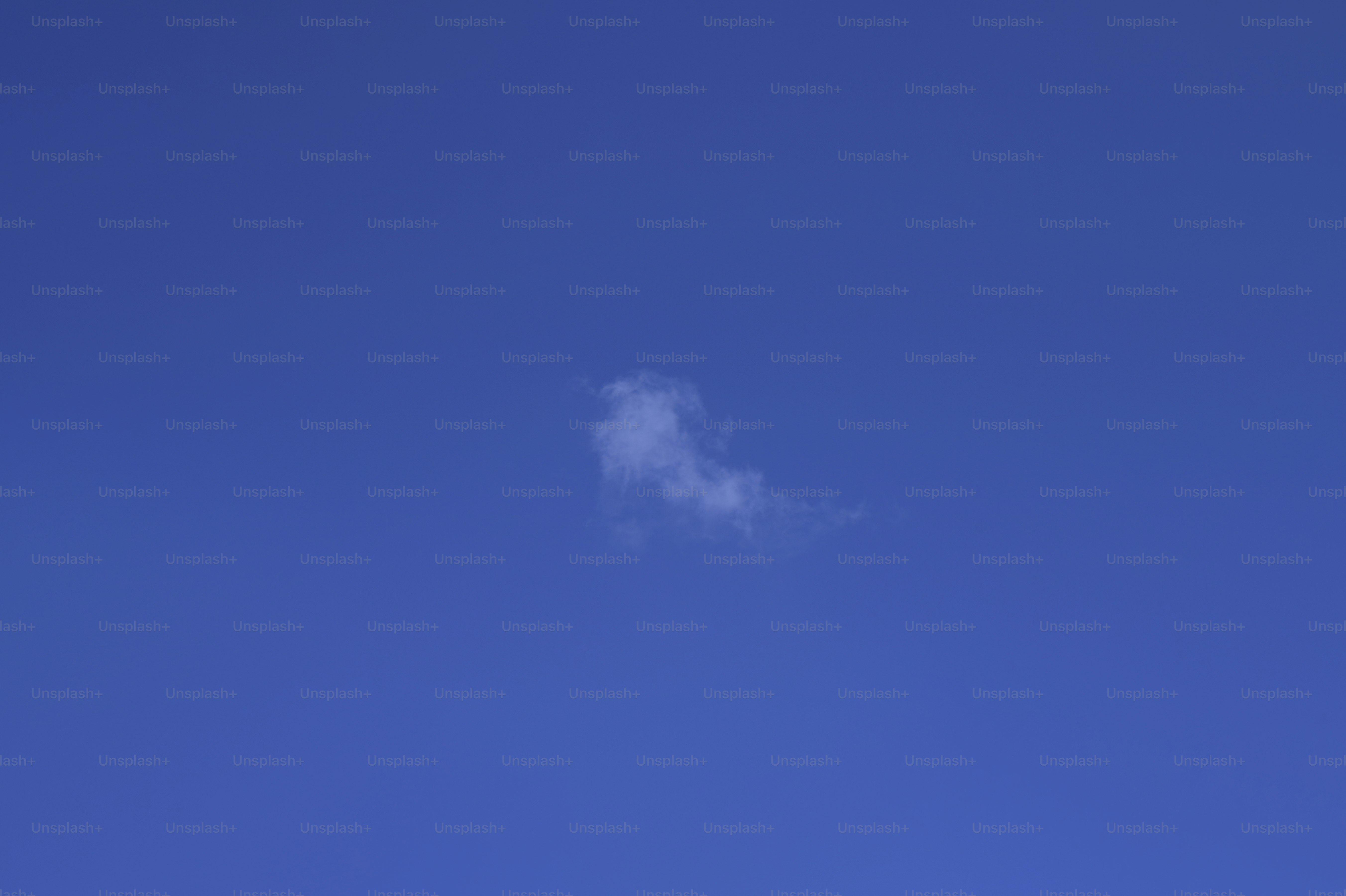 A clear blue sky with a single small white cloud.