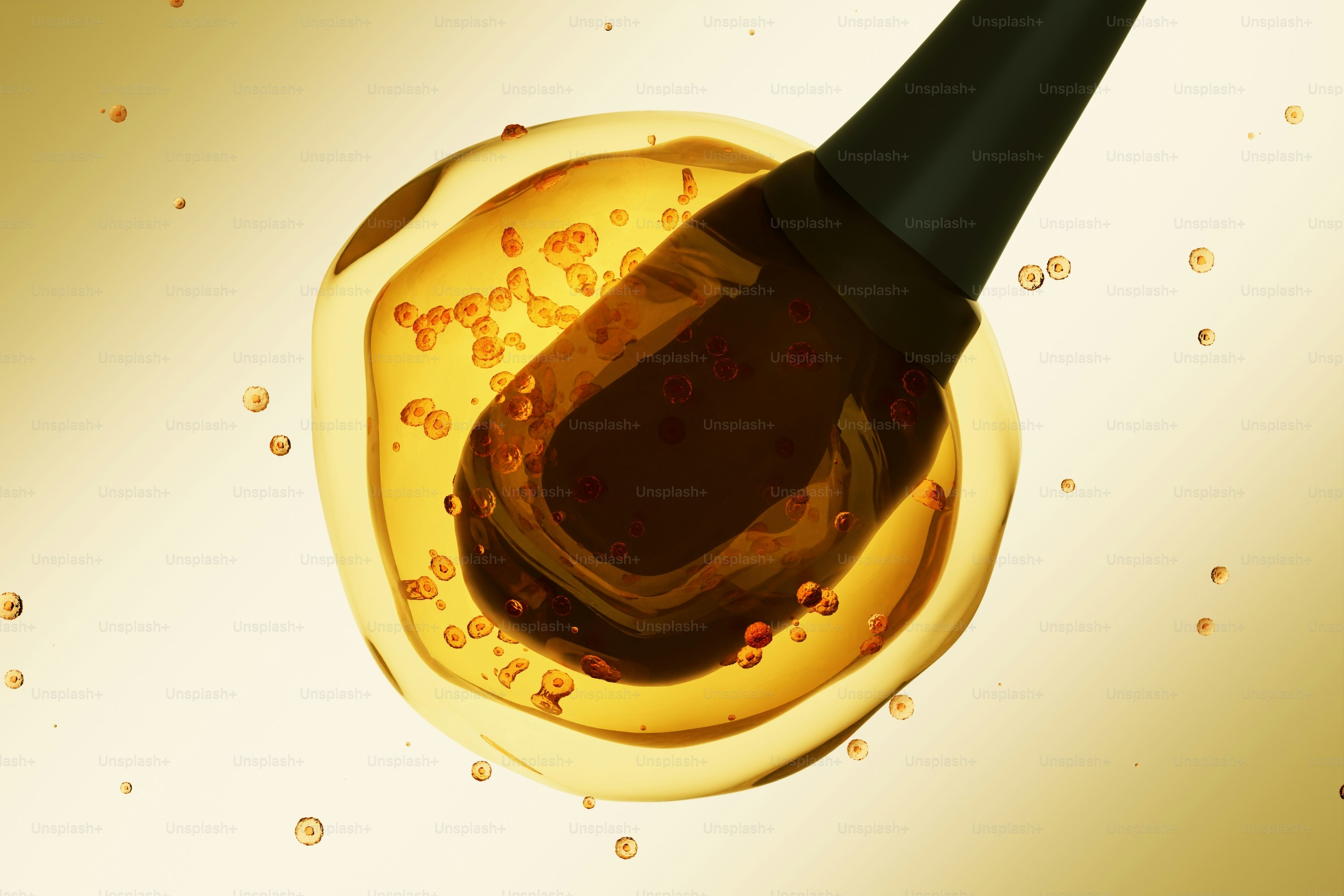A dropper dispenses dark liquid into a golden oil drop.