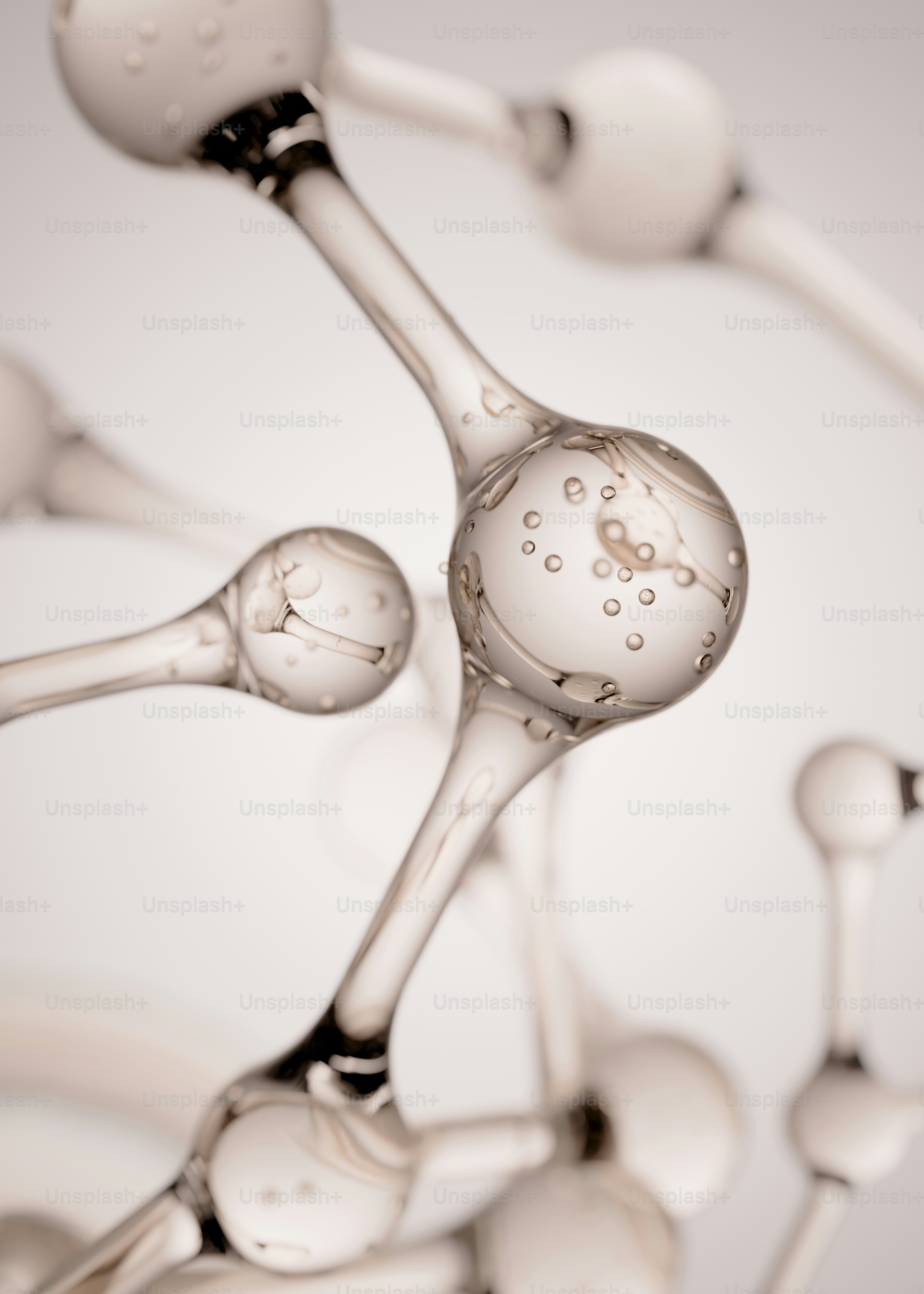 Clear glass molecular structure with bubbles against a light background.