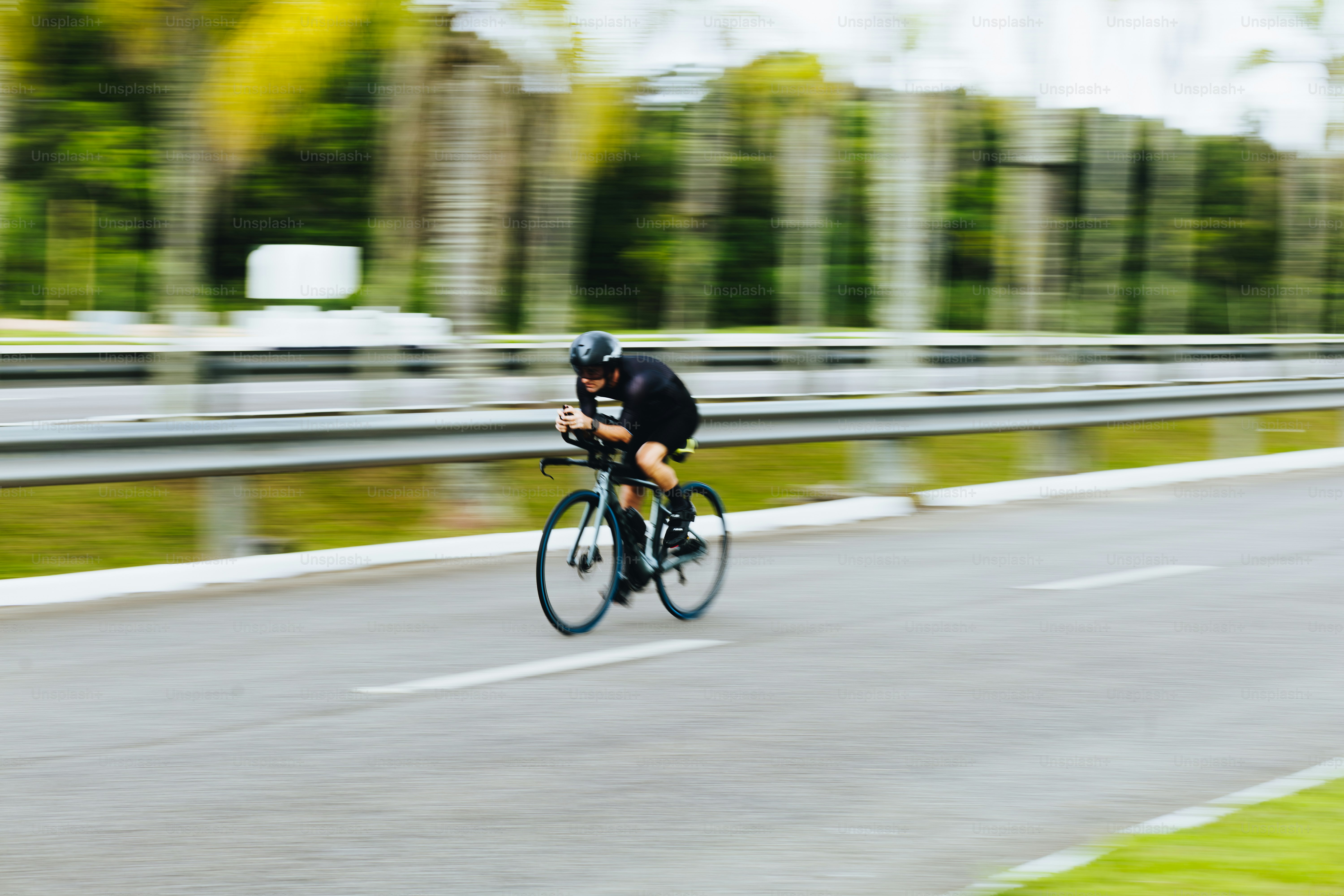 A cyclist speeding on a road with motion blur.