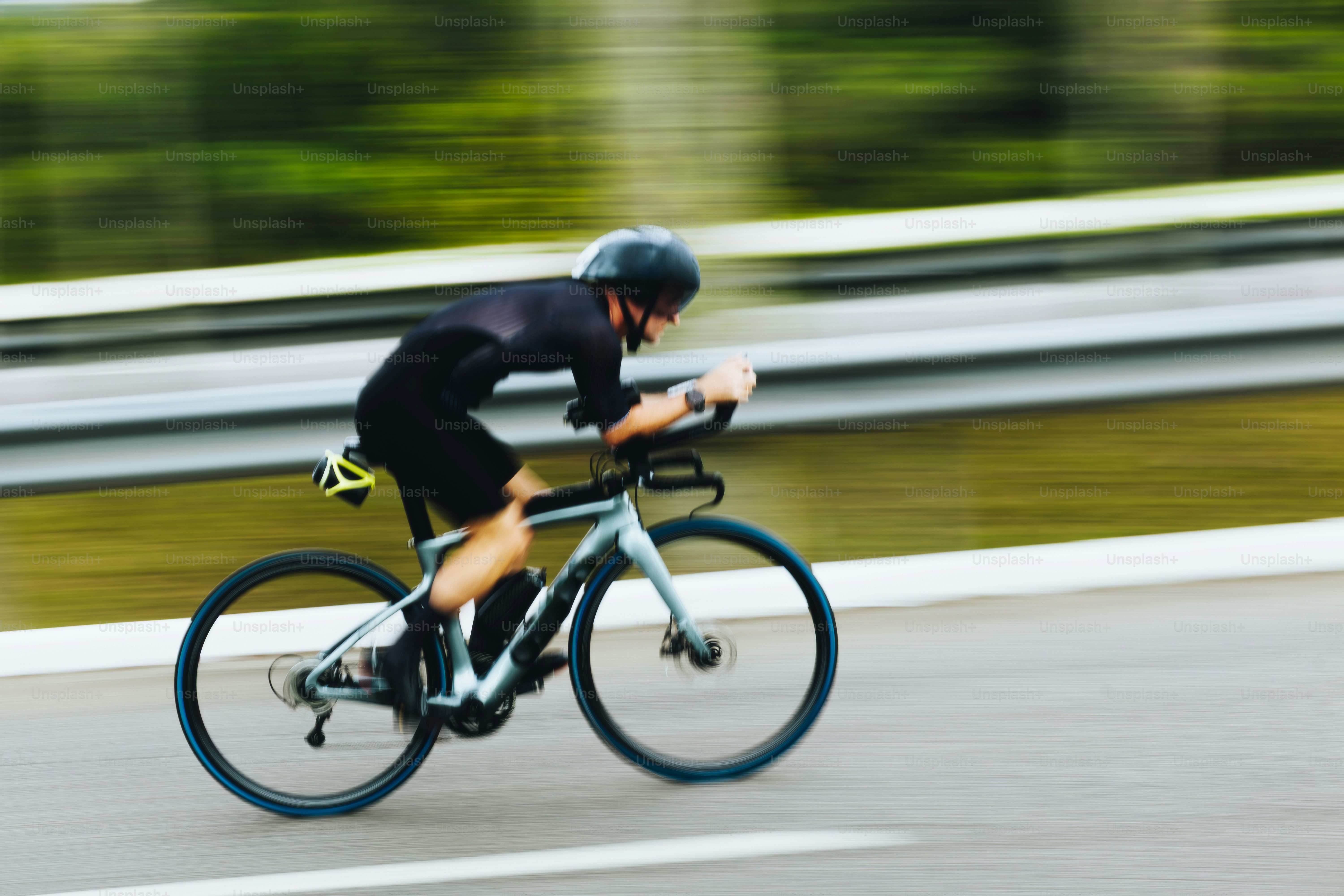 A cyclist speeding on a road with motion blur