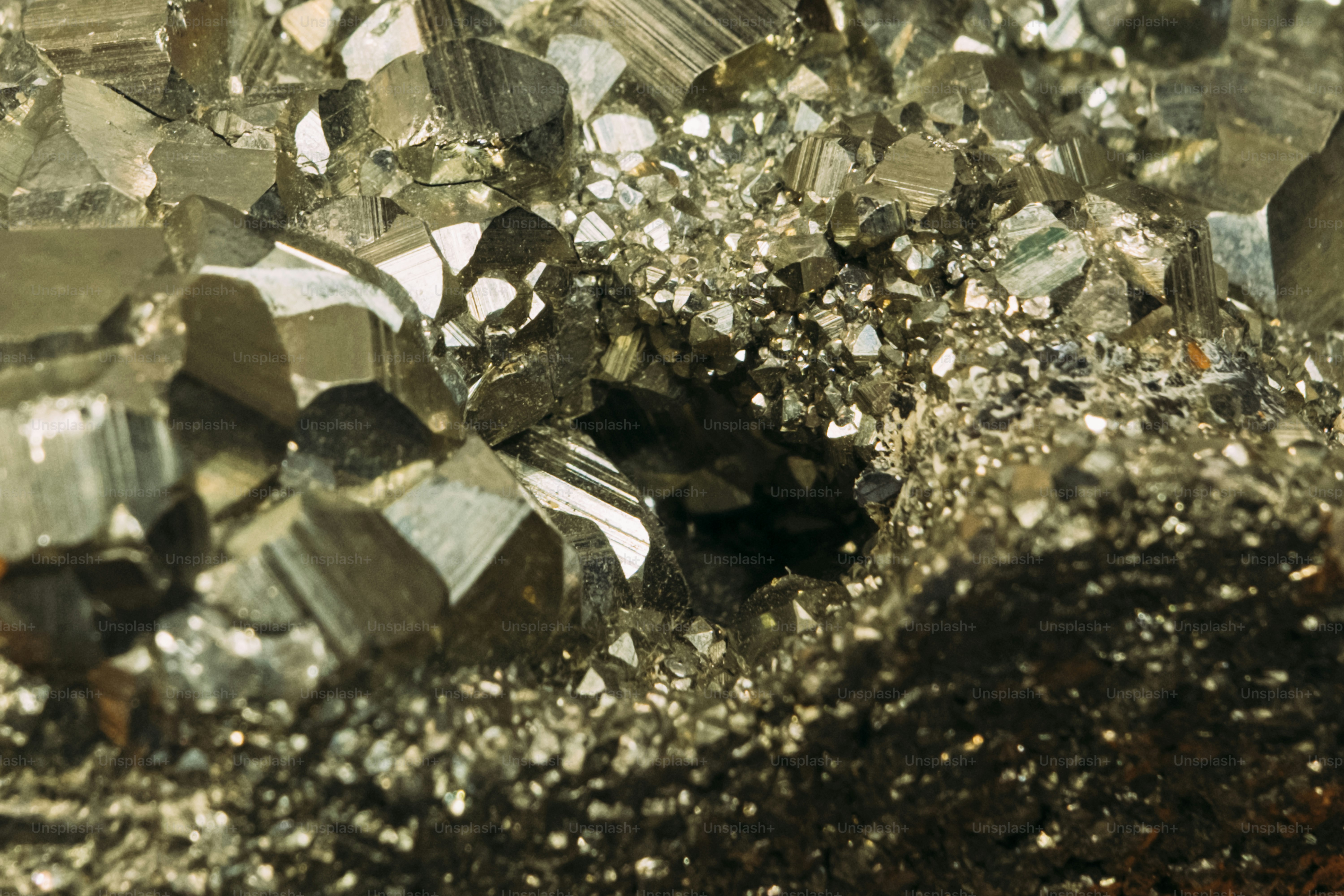 Close-up of shiny pyrite crystals with a dark crevice