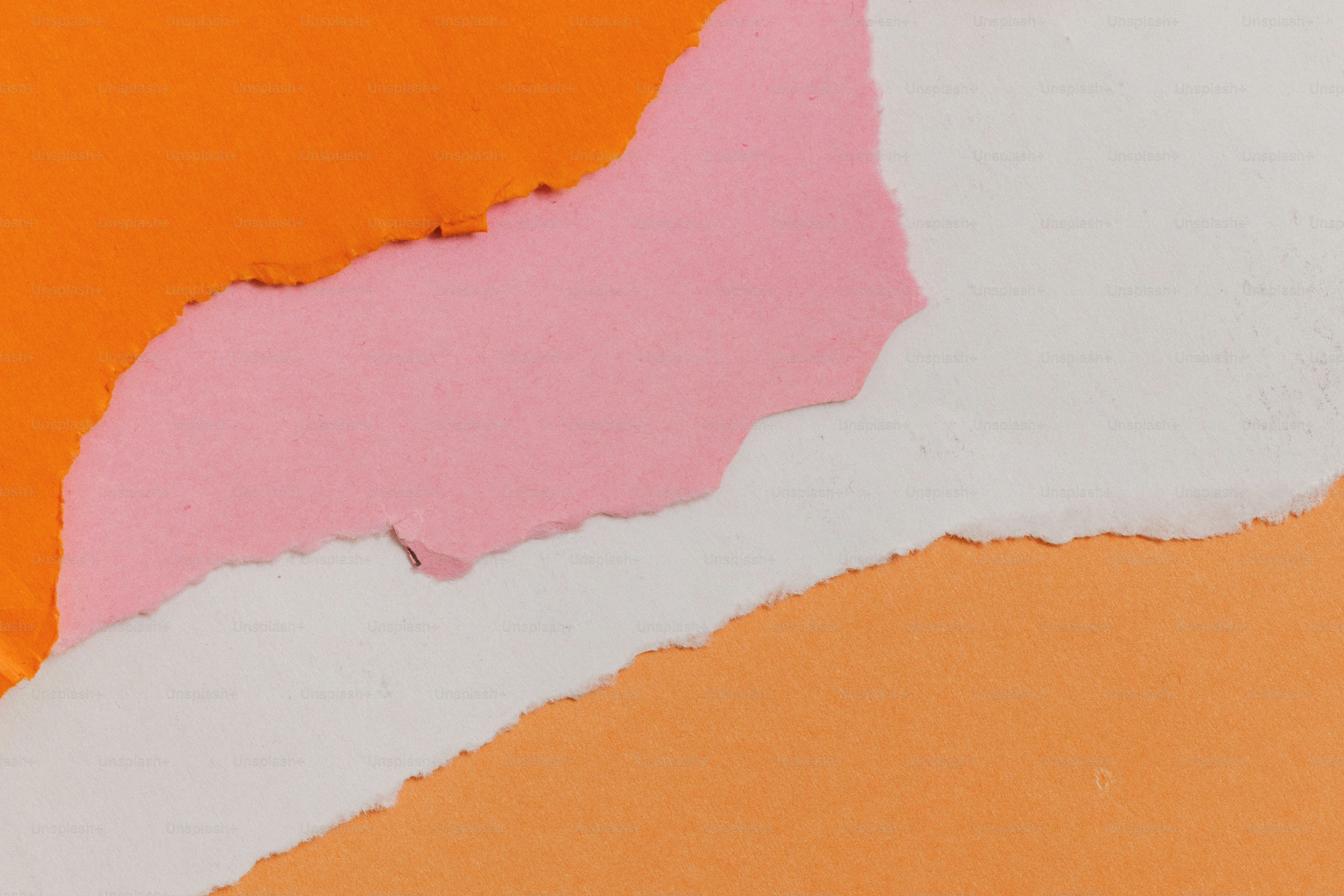 Layers of torn orange, pink, and white paper.