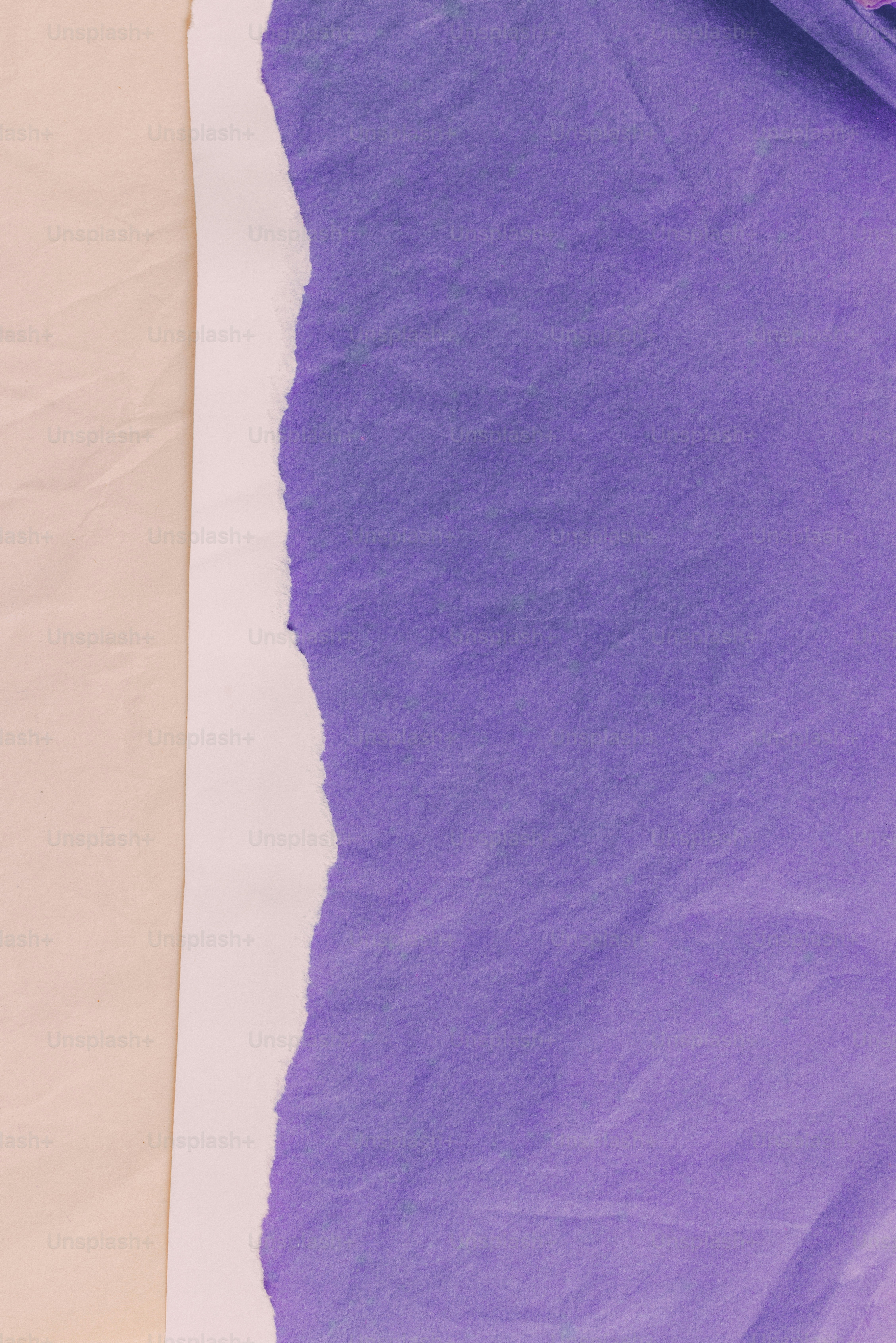 Torn purple paper on a beige background with white edge.