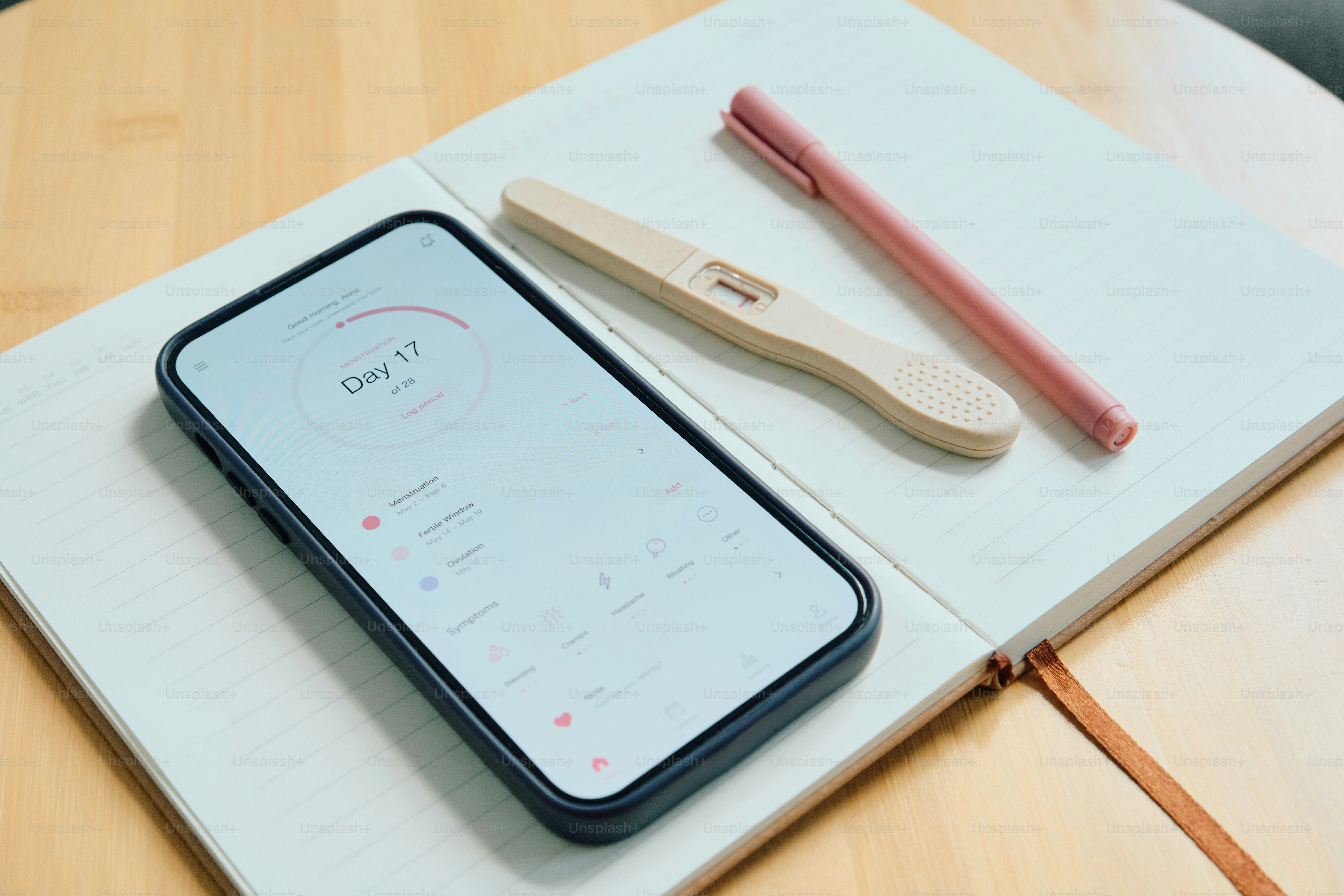 Test de grossesse positif avec application de suivi de la fertilité sur smartphone.