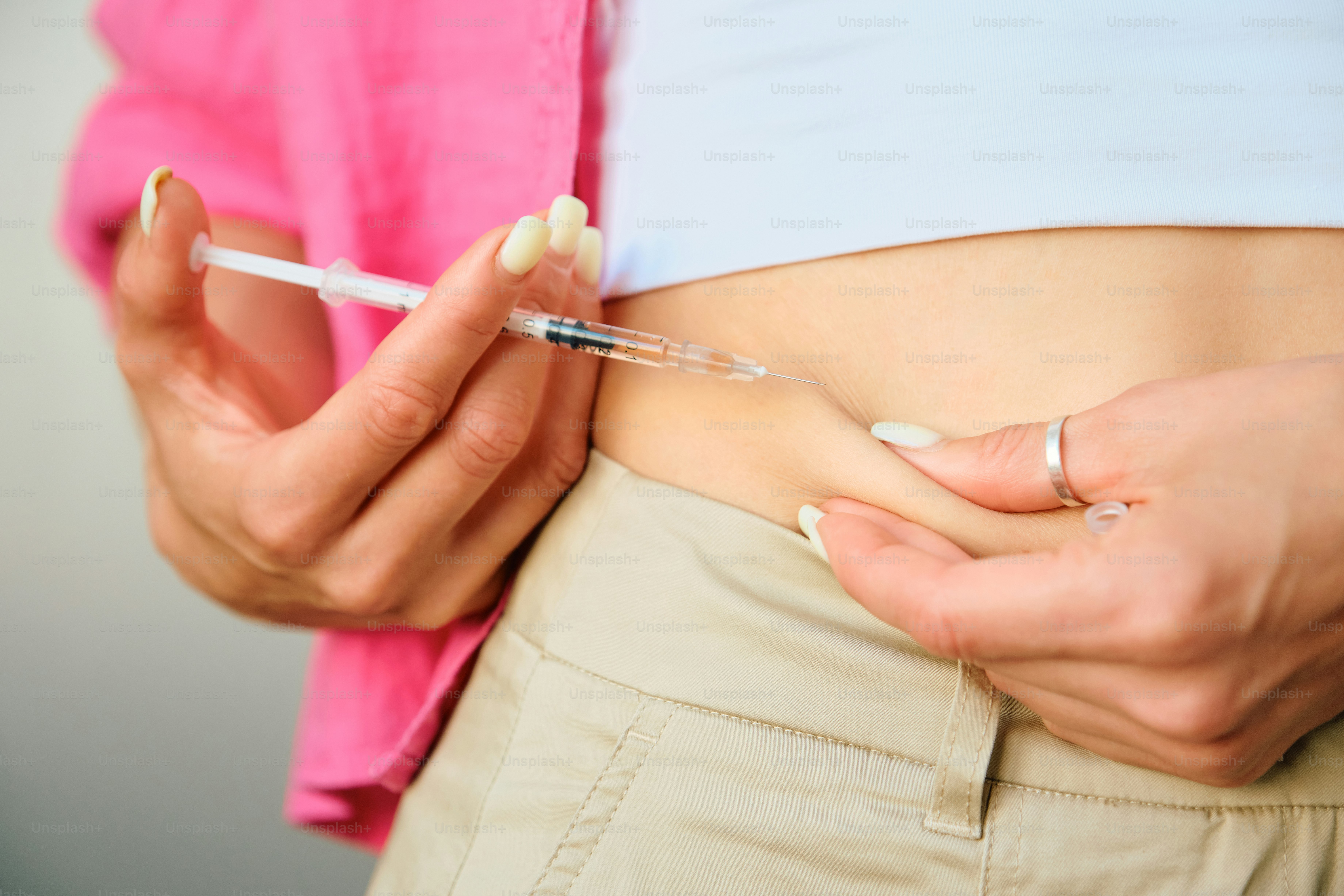 Femme qui s’injecte des médicaments dans l’estomac.