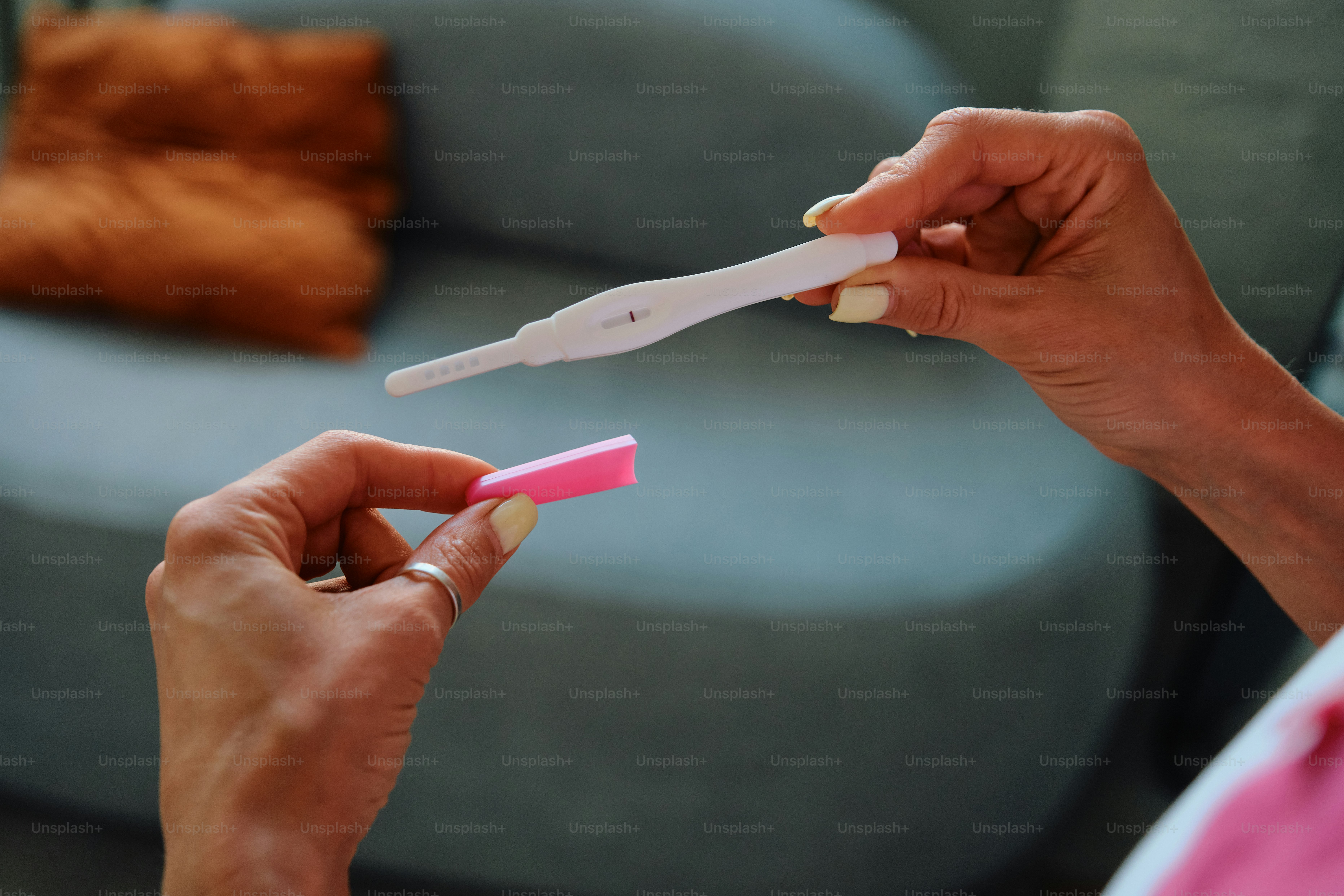 Les mains d’une femme tenant un test de grossesse positif.