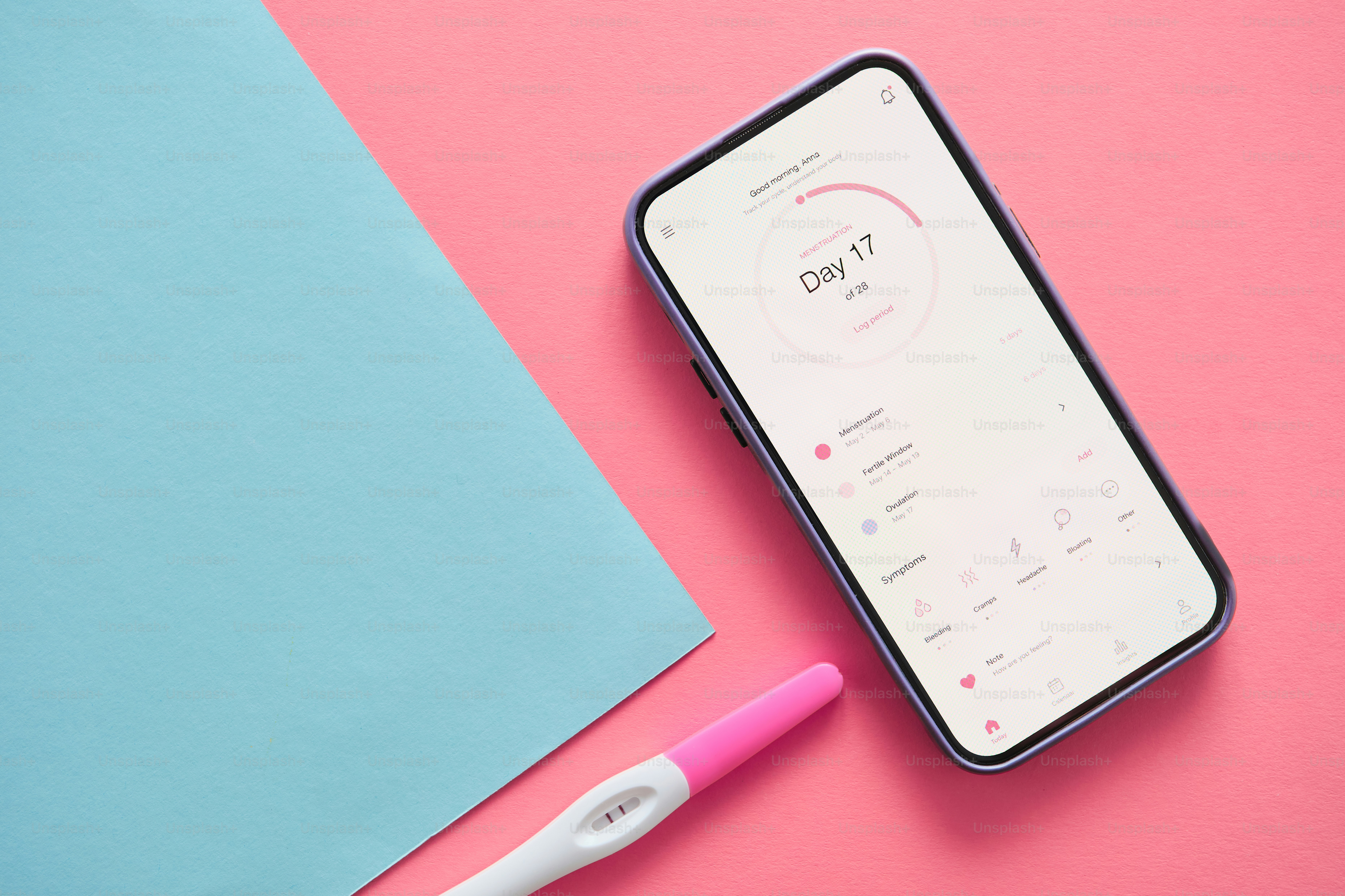 Un smartphone avec une application de fertilité et un test de grossesse.