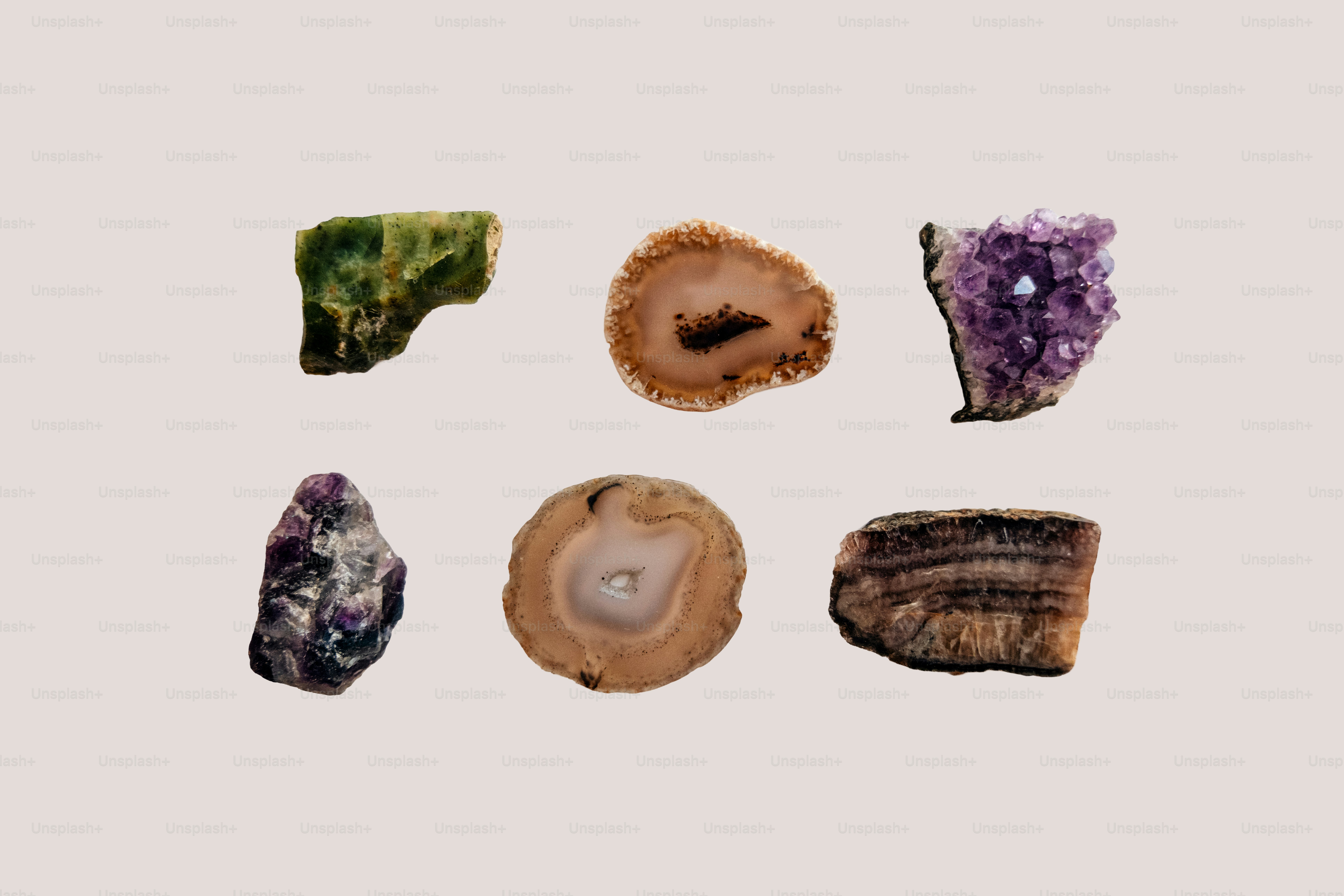 Various colorful crystals and sliced geodes on a light background.