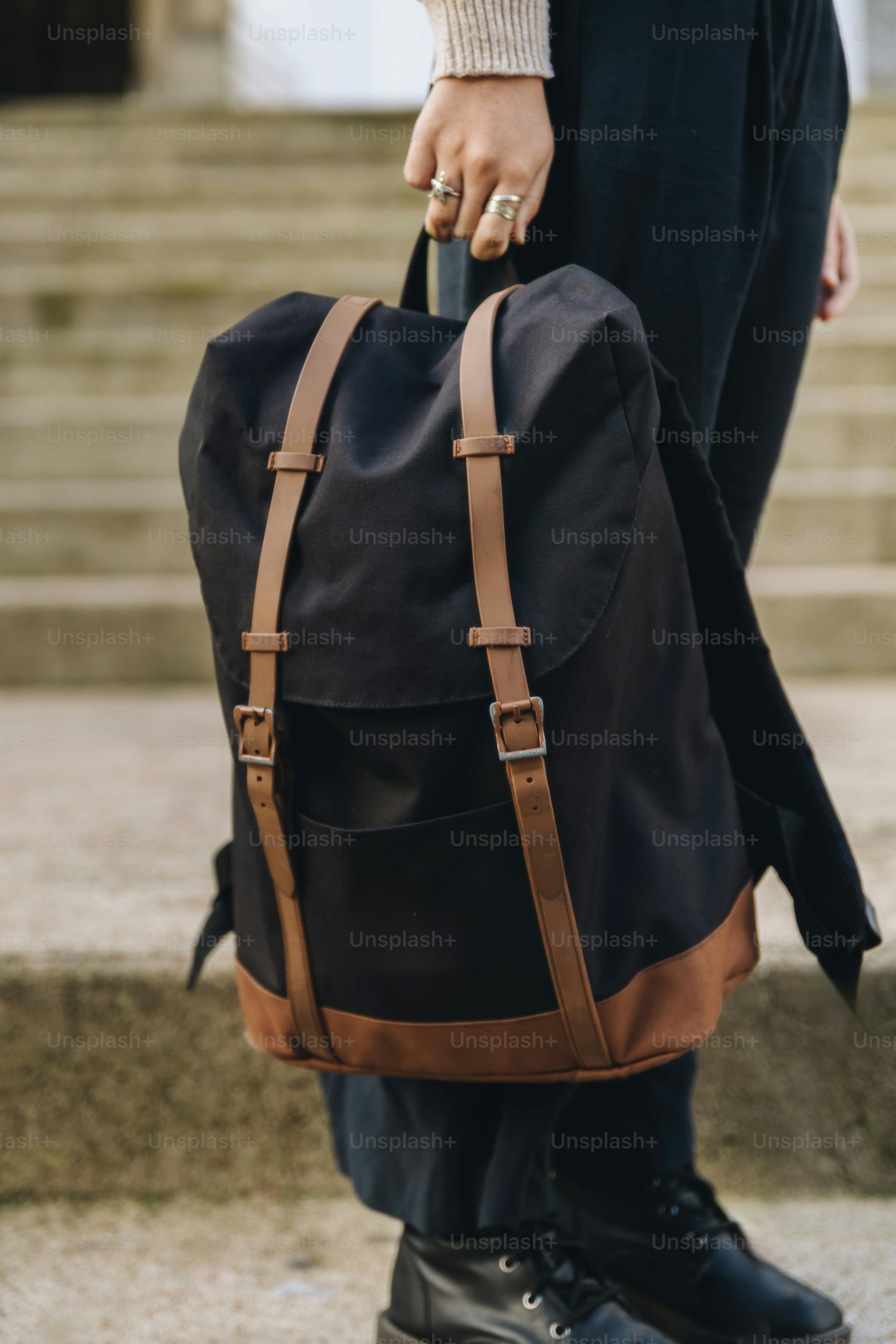 black backpack with brown leather straps A person holds a black backpack with brown leather straps. photo – Travel  Image on Unsplash