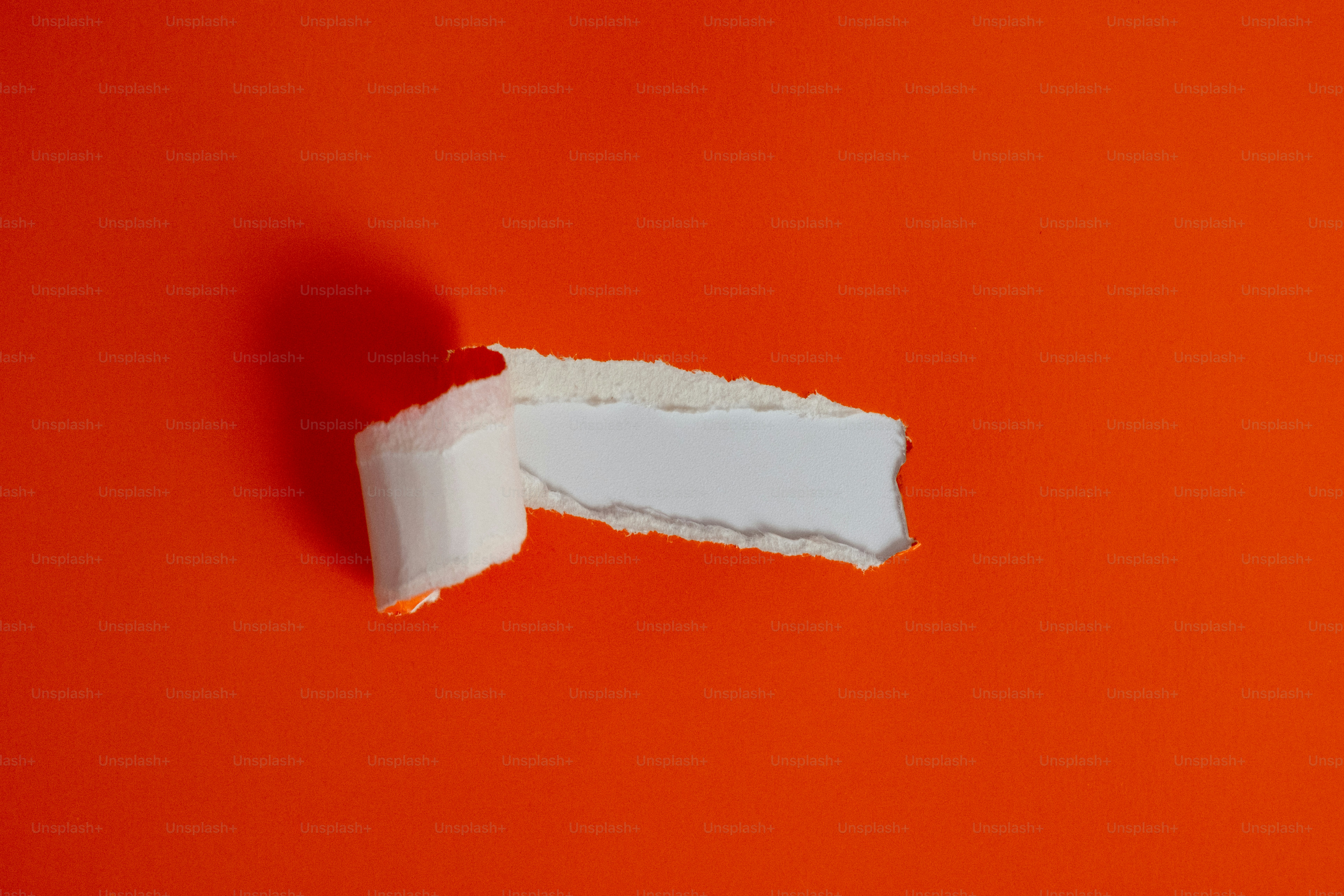 Torn white paper on a vibrant orange background.