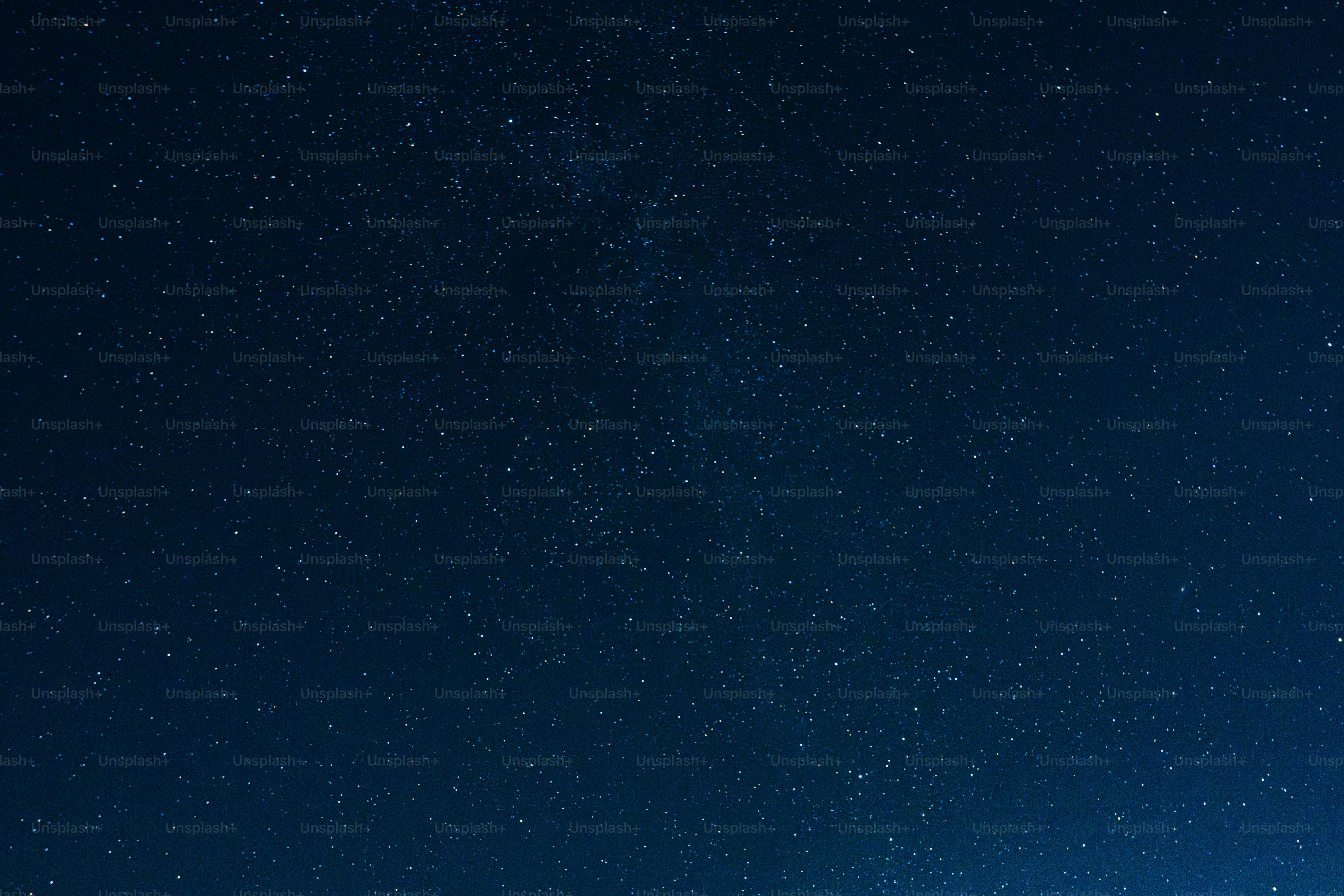 A dark blue night sky filled with many twinkling stars.