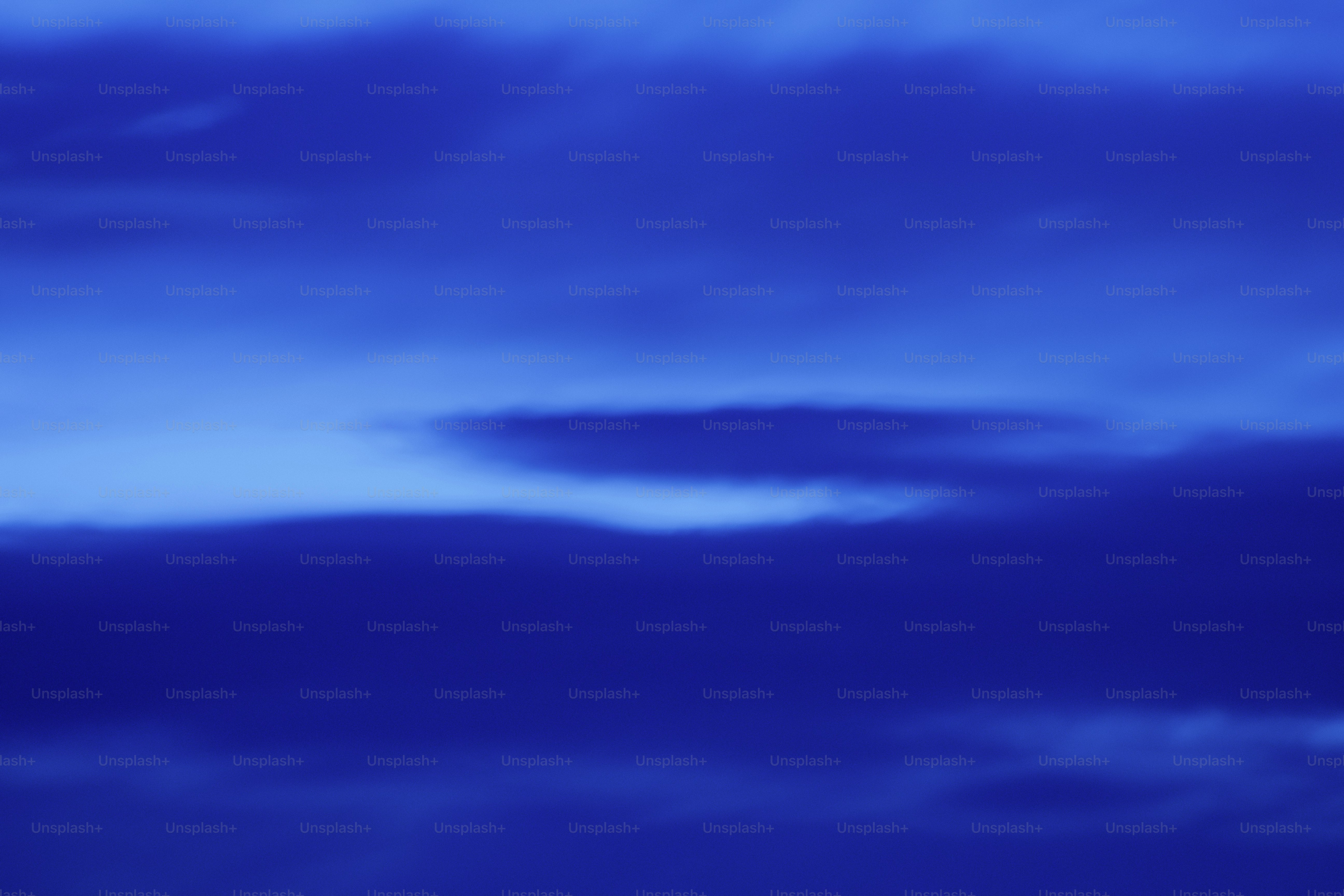 Langit biru tua dengan formasi awan halus.