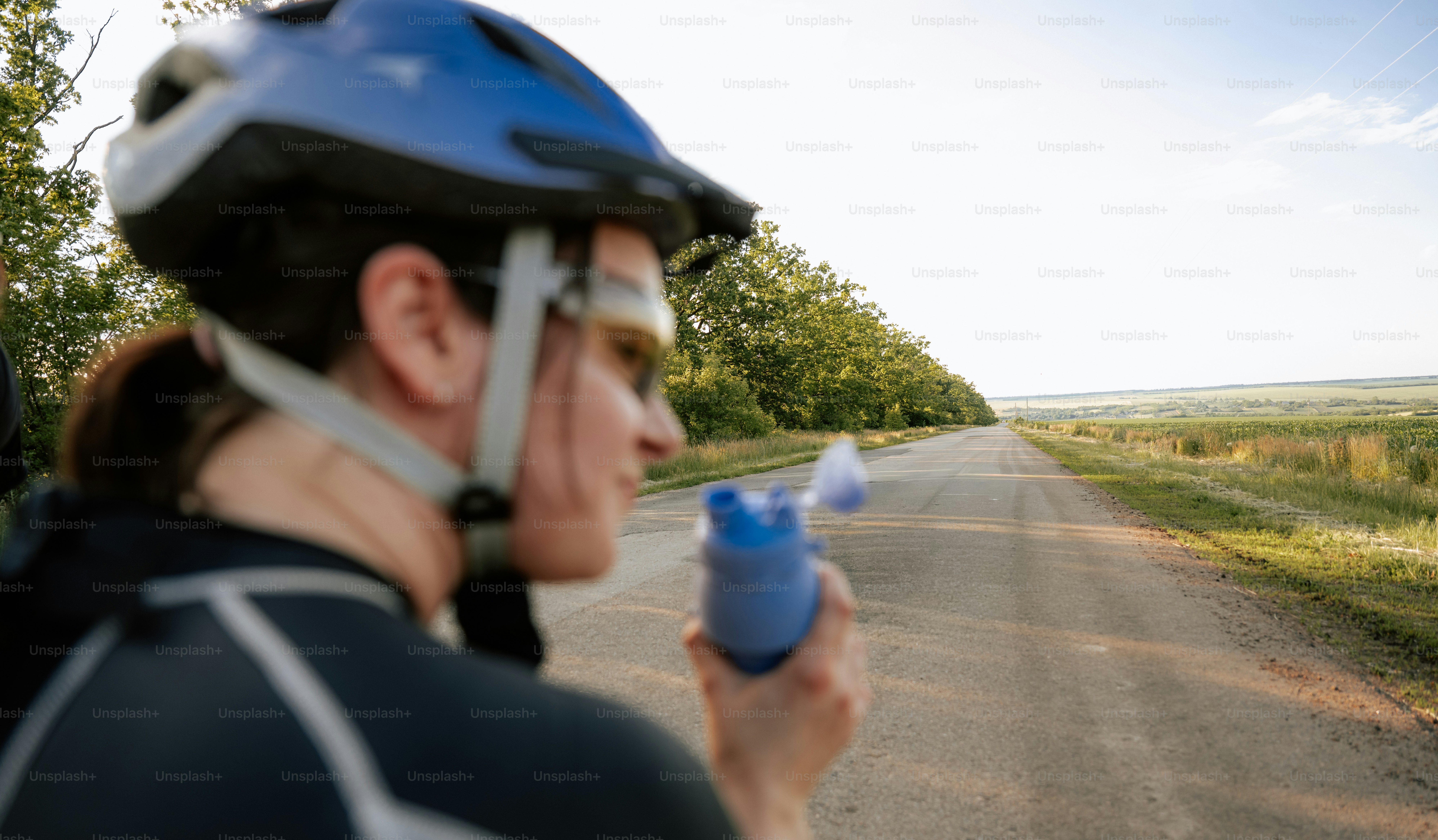 Cycliste utilisant un inhalateur sur une route de terre.