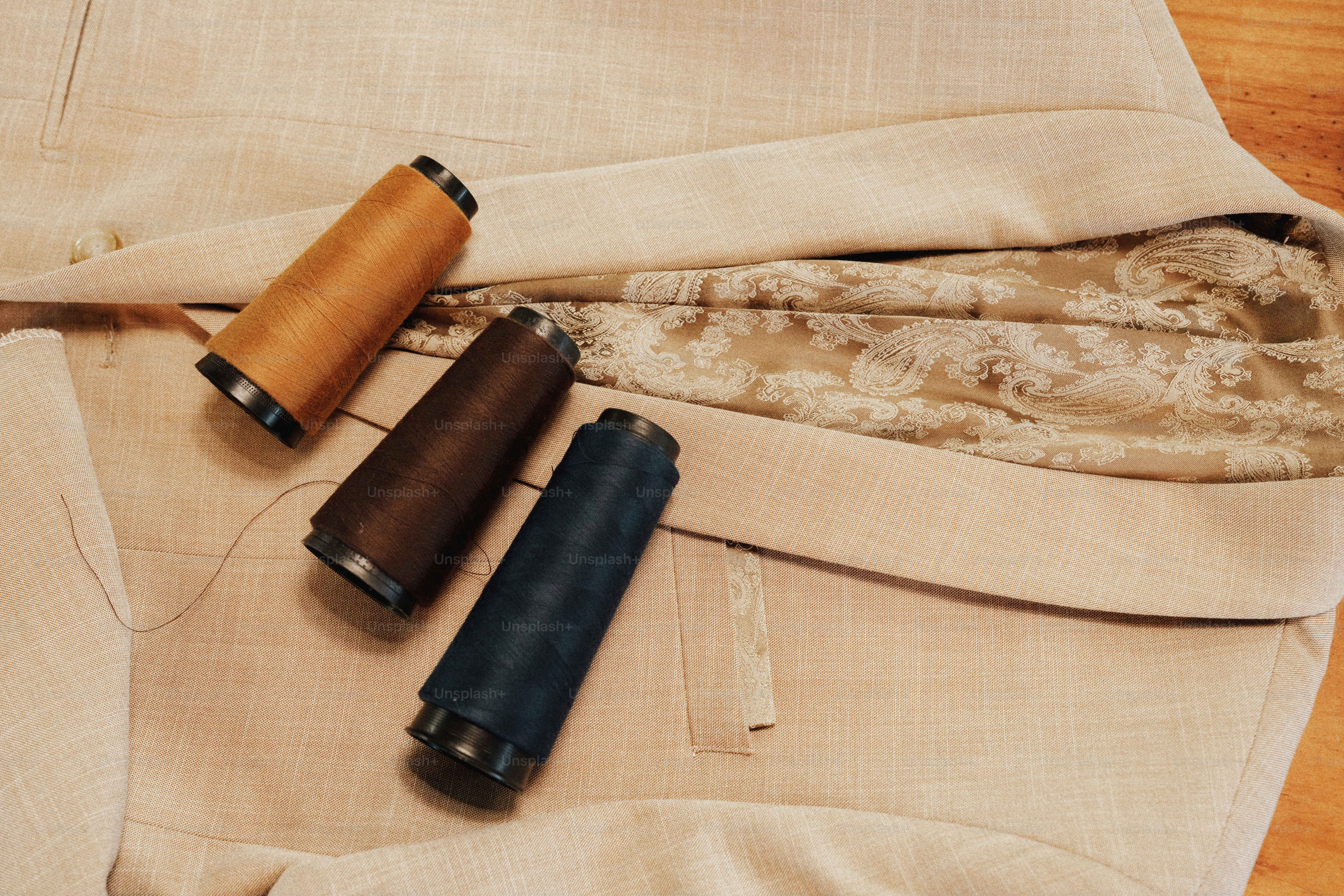 Colorful thread spools resting on light fabric. photo – Clothing Image ...
