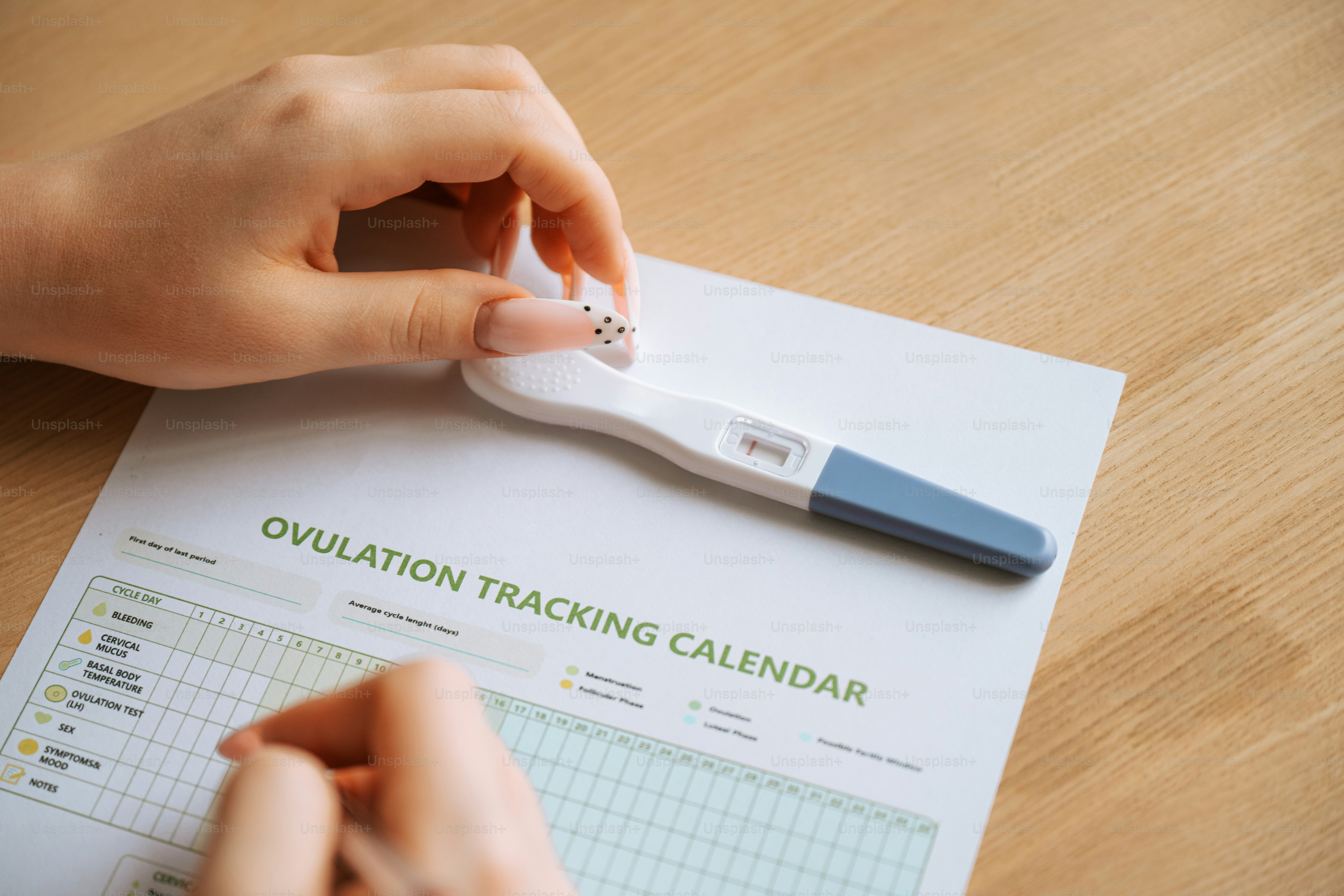 A pregnancy test lying on a calendar with heart stickers. photo ...