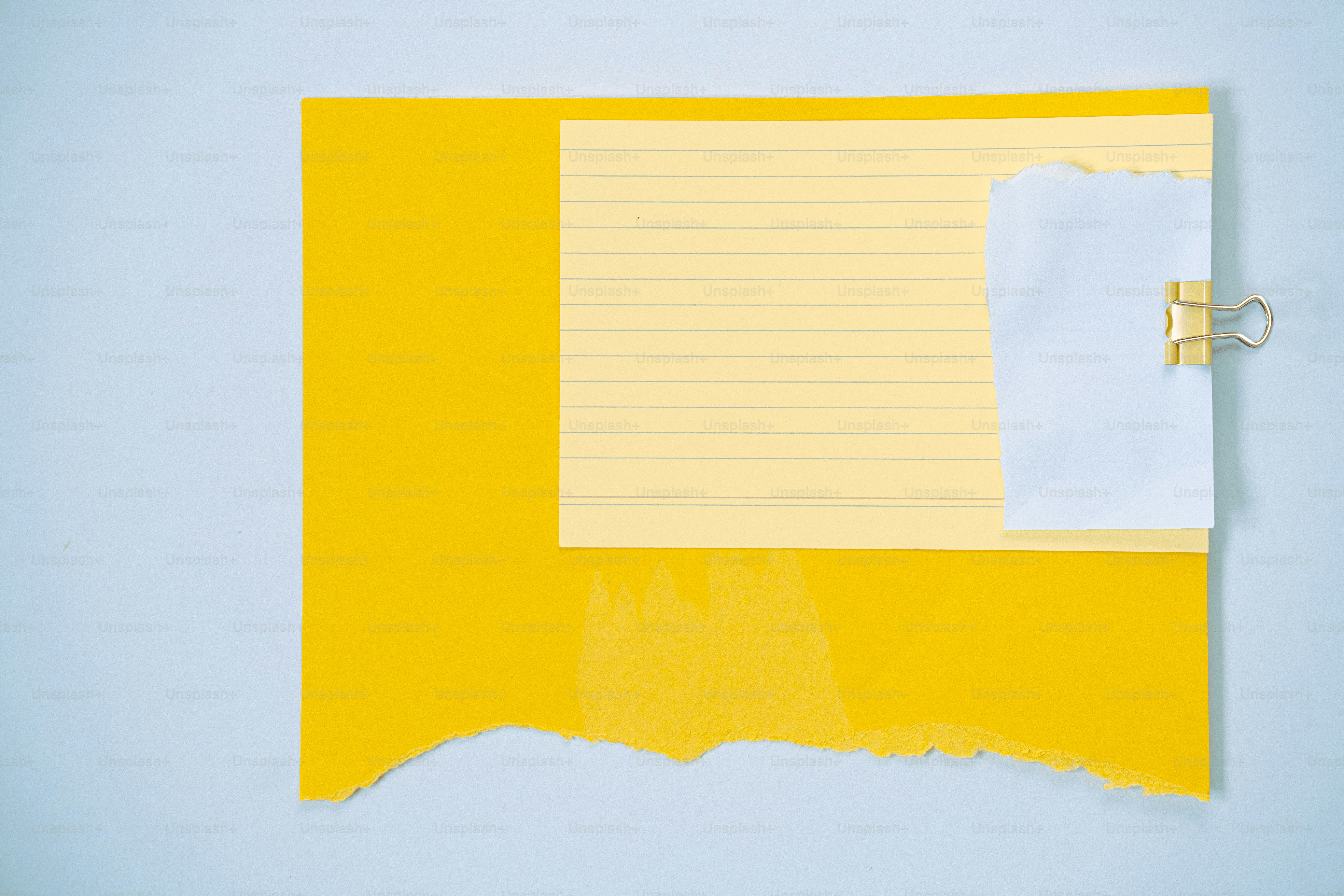 Papier jaune déchiré, carnet de notes ligné, et un mot blanc éclipsé.