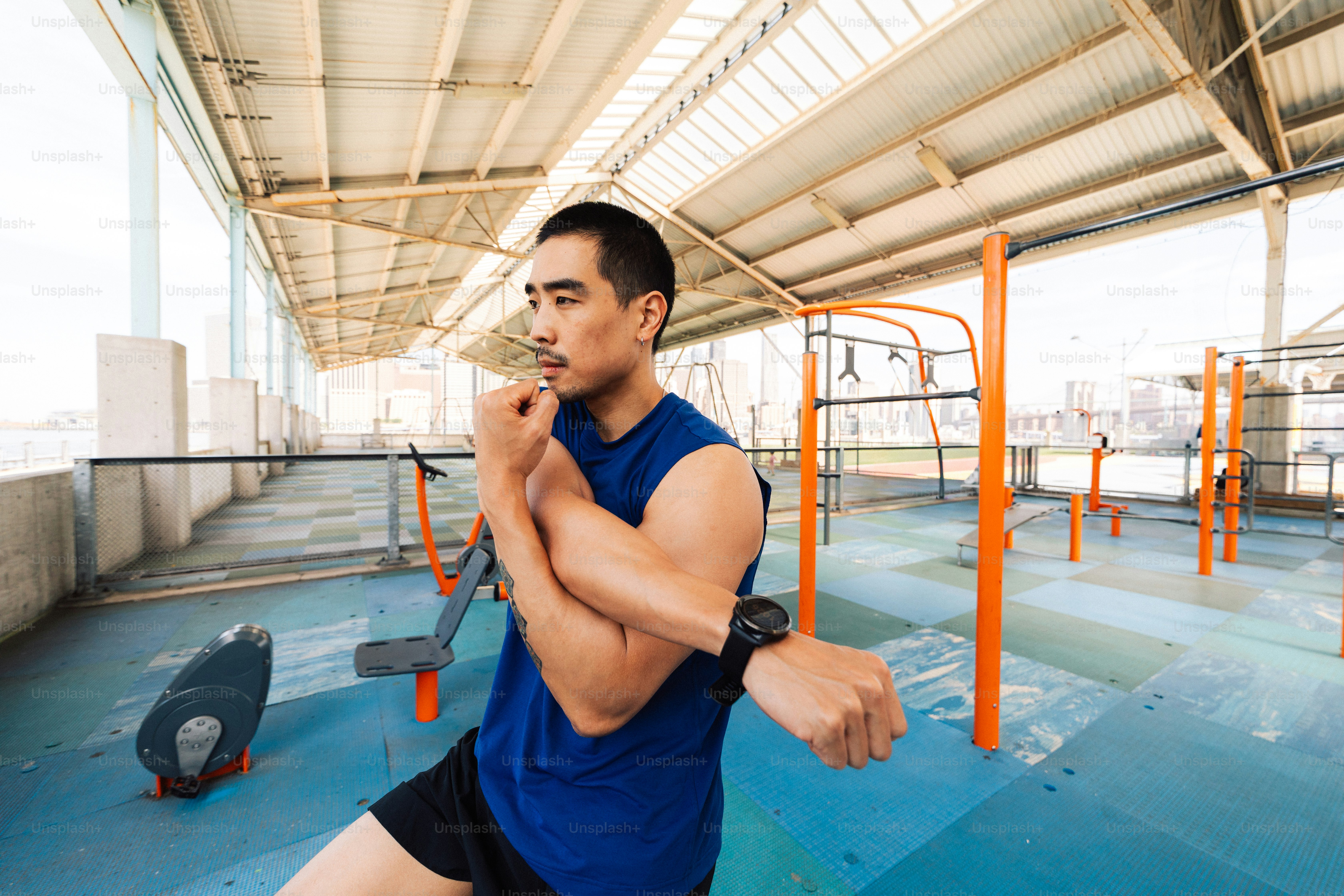 Seorang pria mengulurkan tangannya di gym luar ruangan.