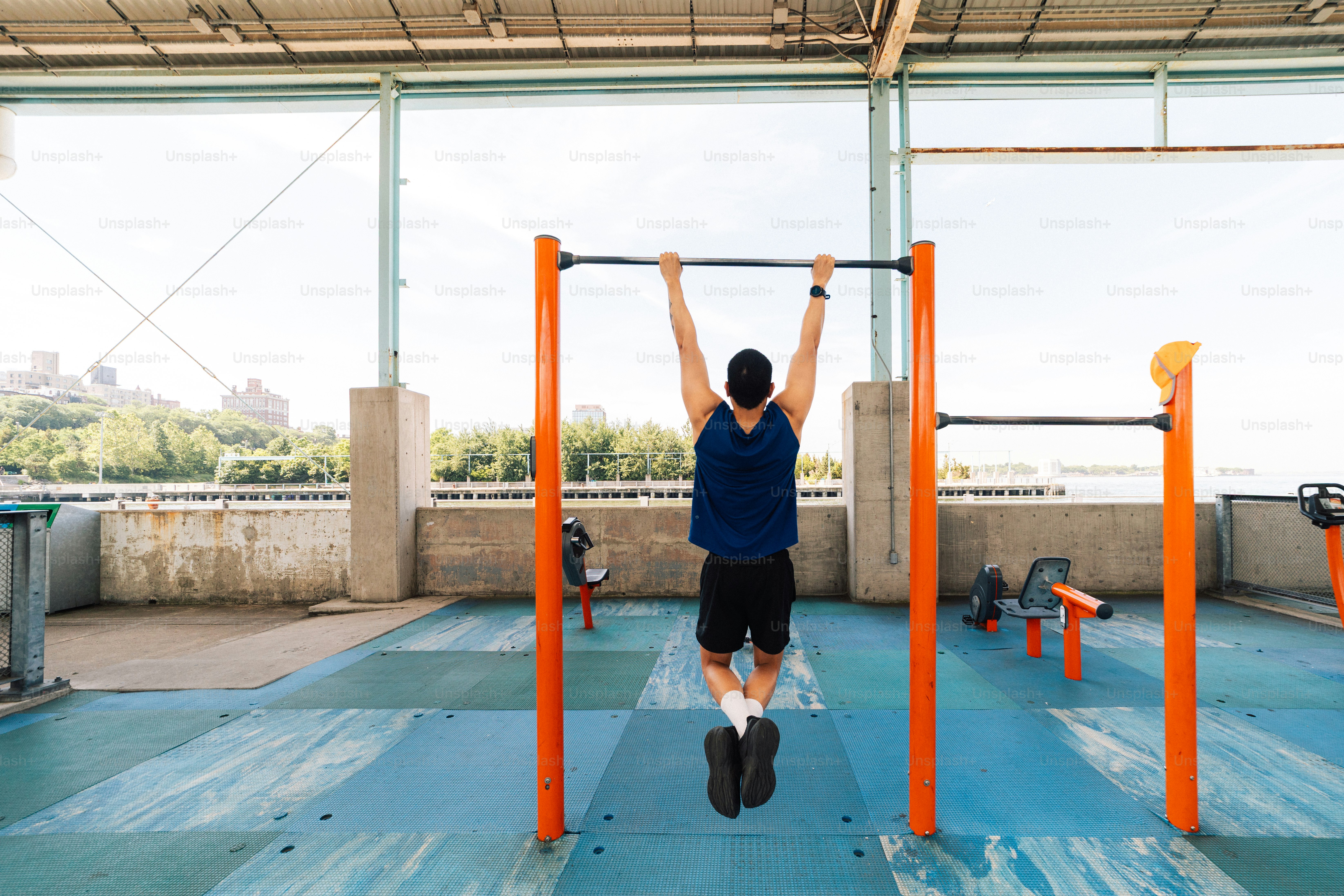 Man exercising on a pull-up bar in an outdoor gym