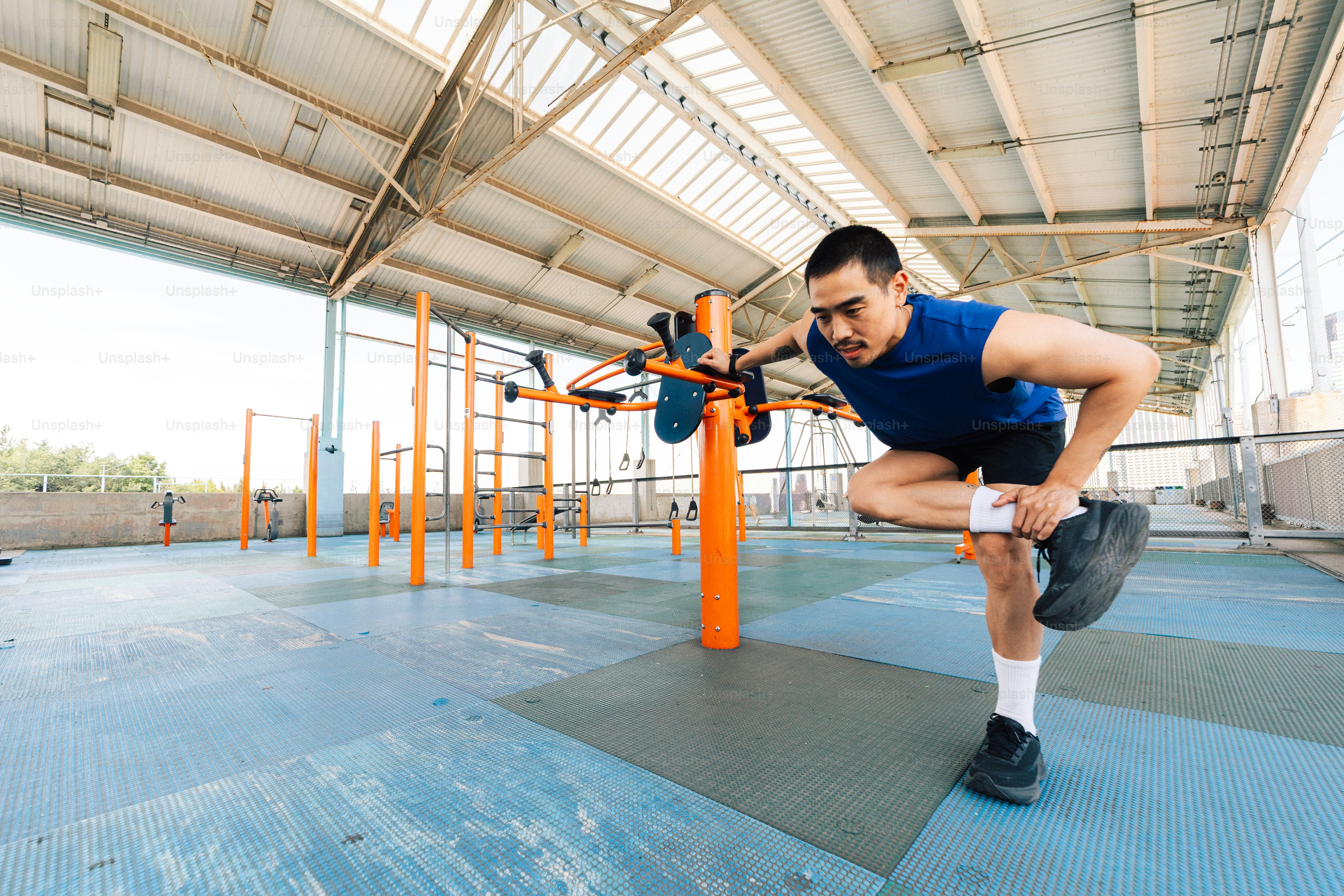 Pria menyeimbangkan dengan satu kaki selama latihan di luar ruangan.