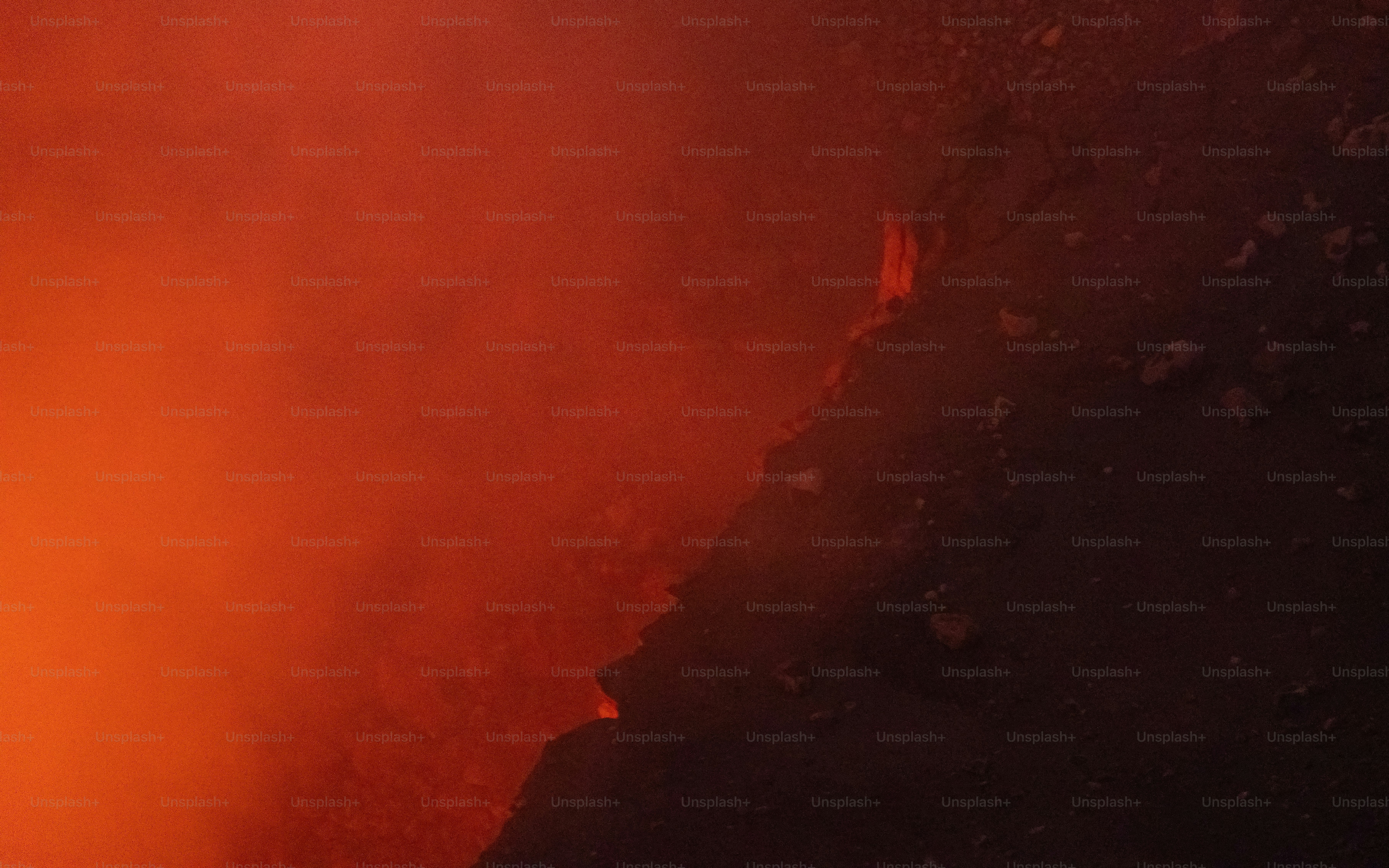 Erupción volcánica con lava roja brillante y humo.
