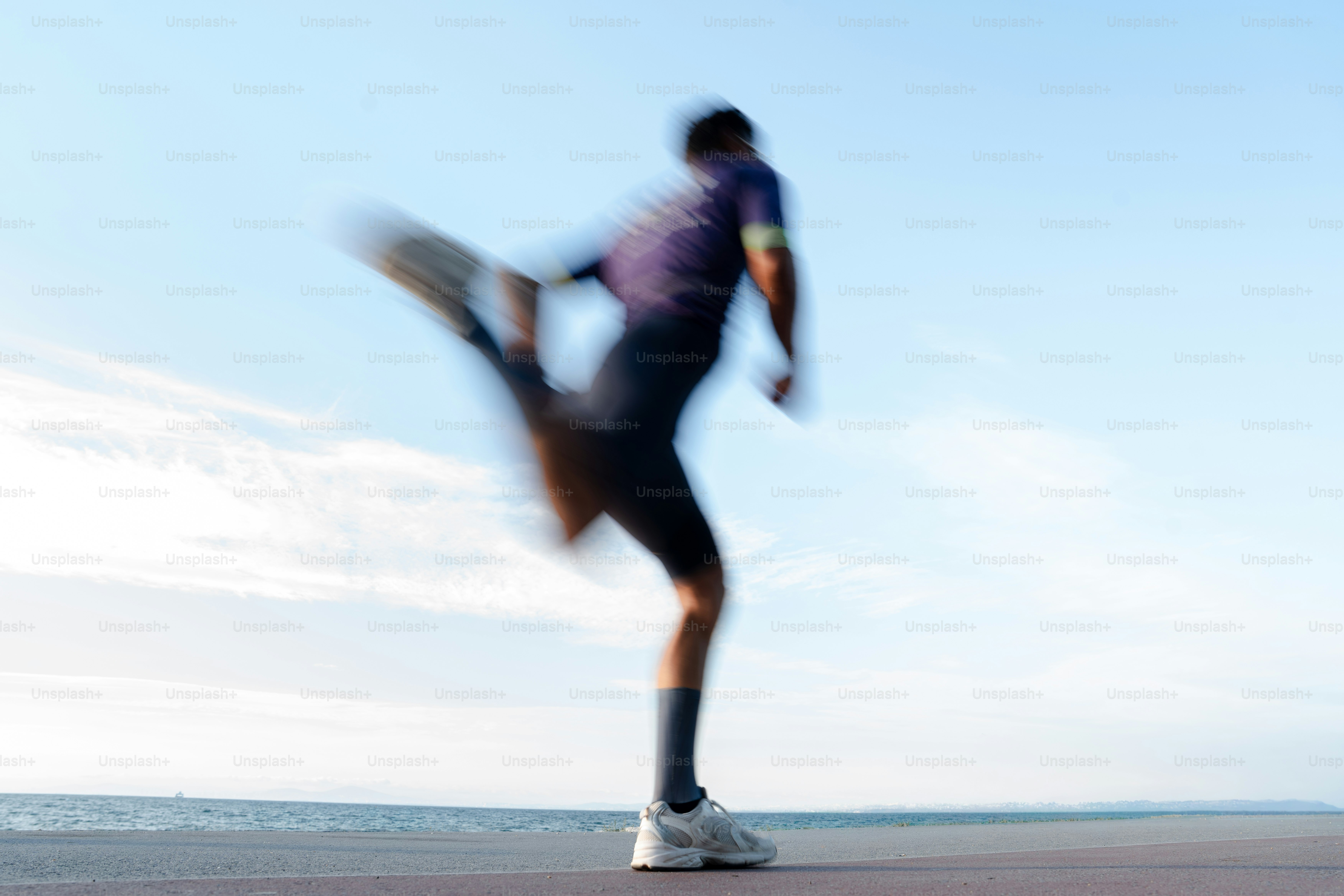 Athlete in motion blur stretching by the sea