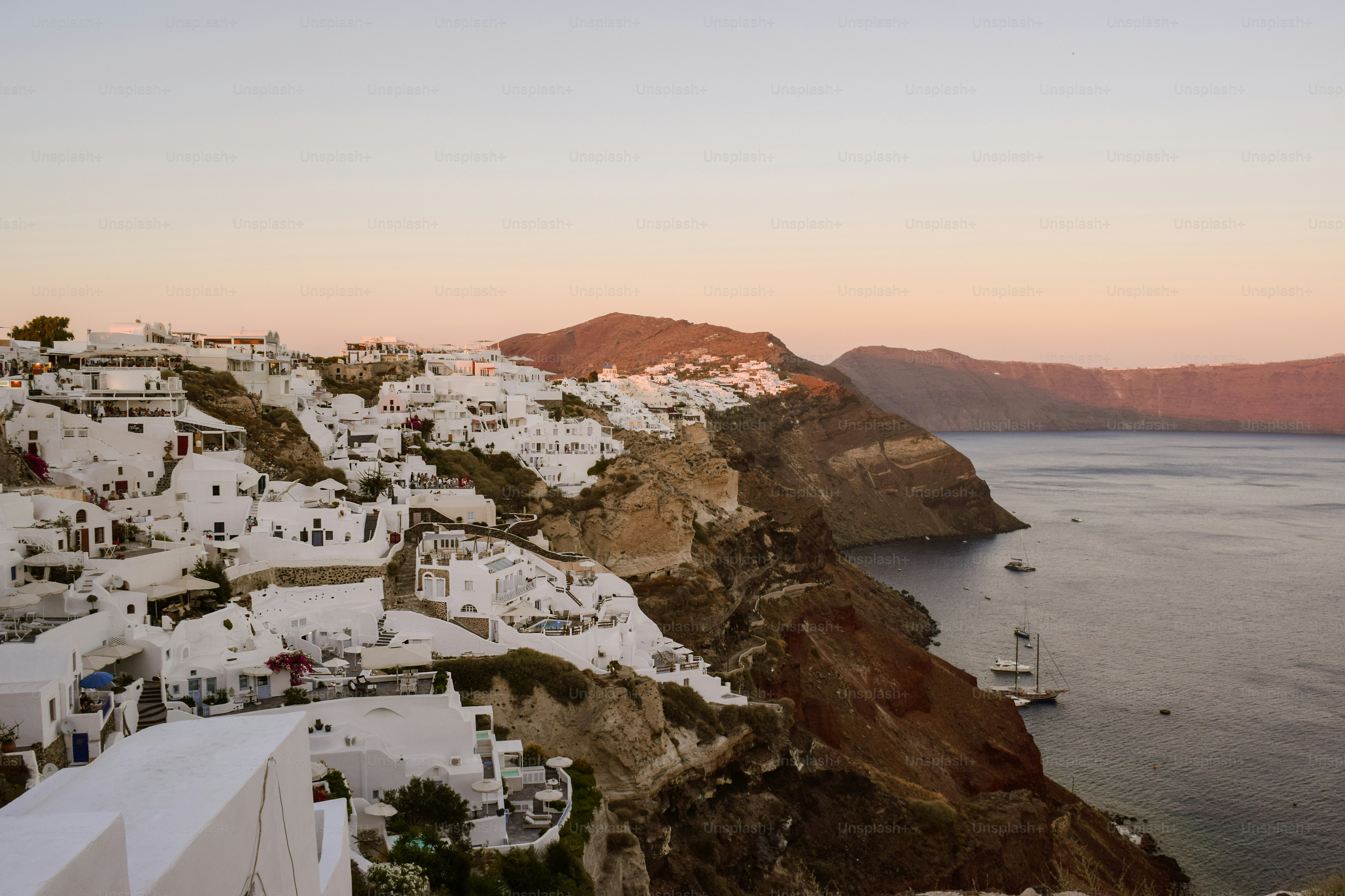 White buildings on fira cliffside overlooking aegean sea