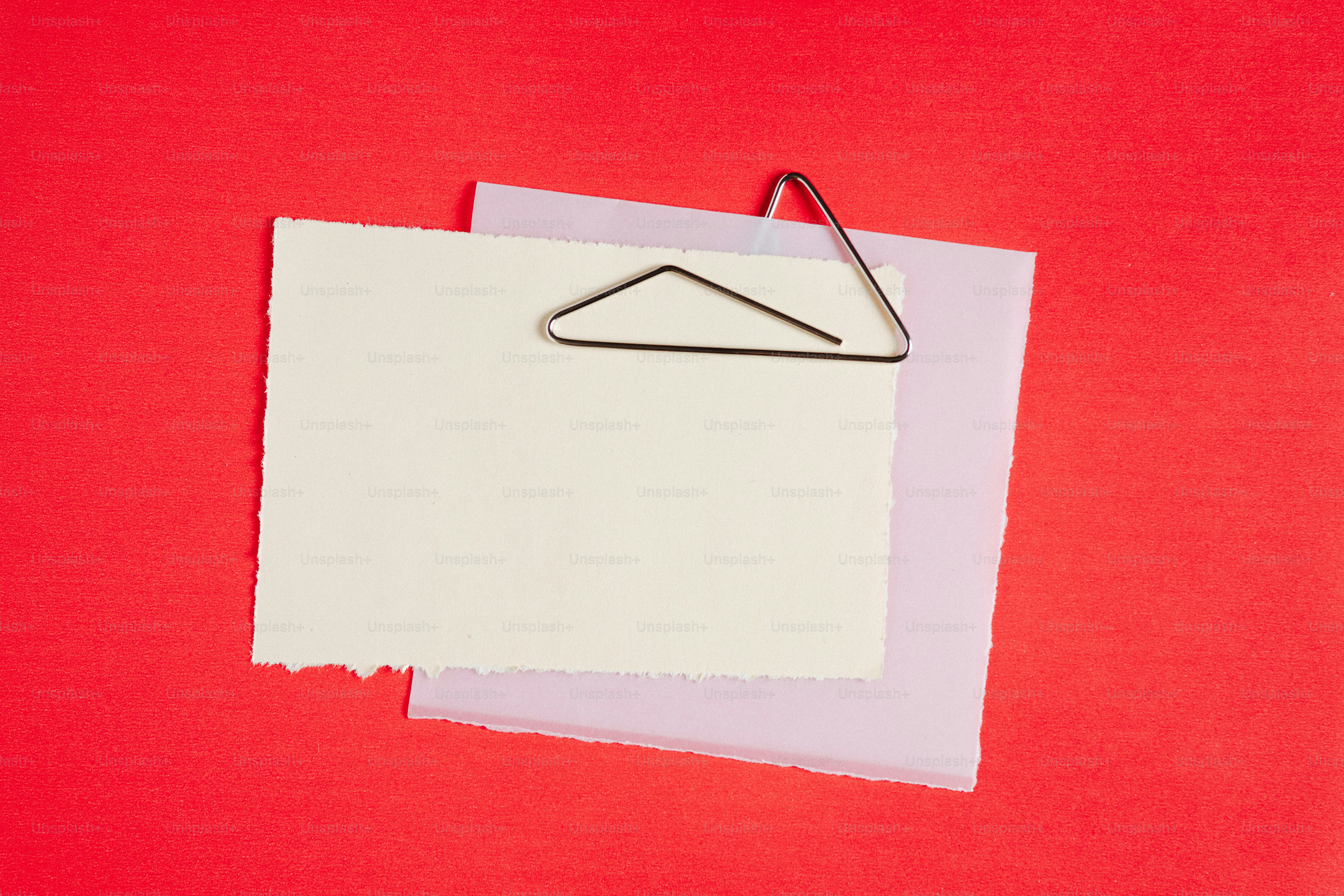 White and purple paper with paperclip on red