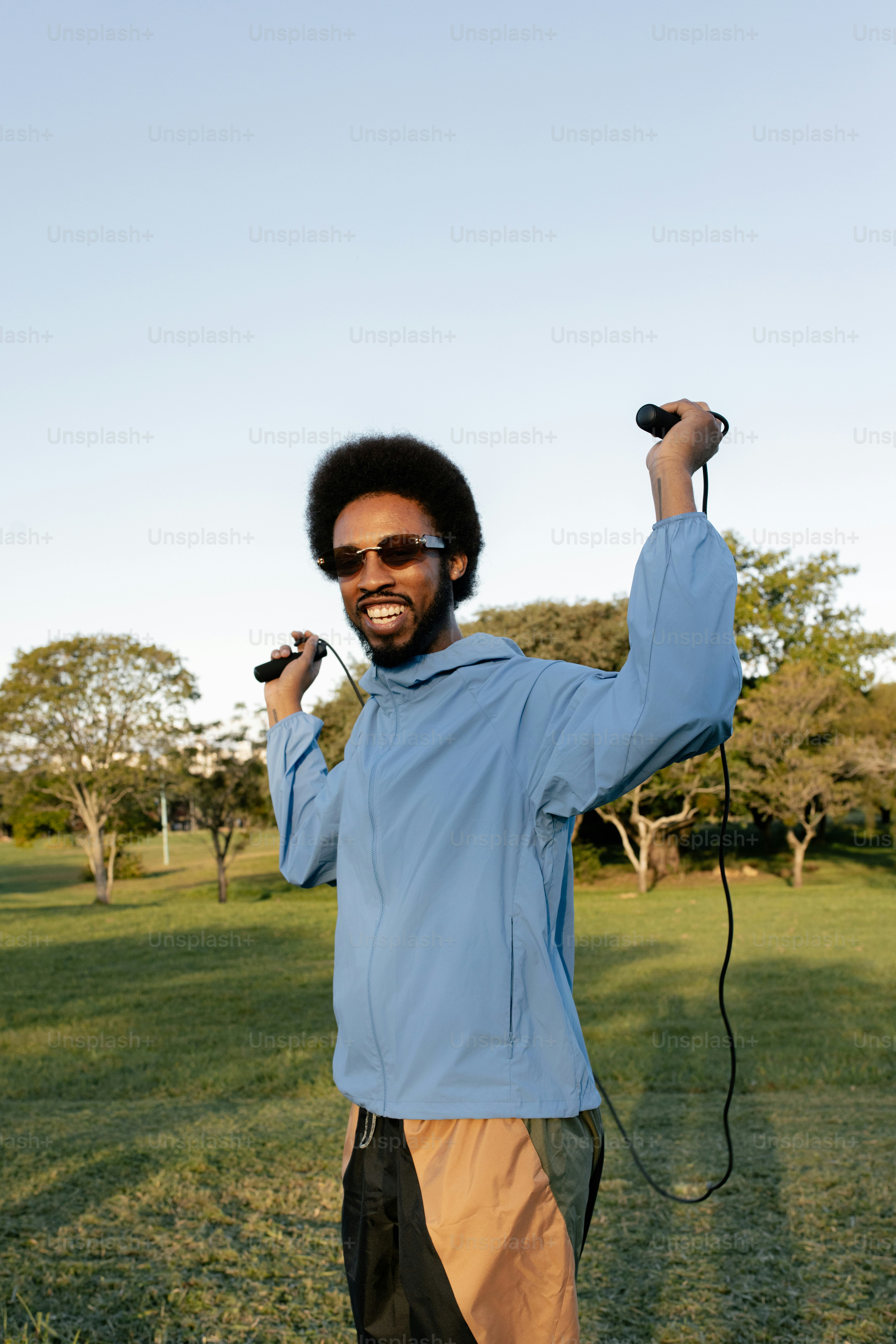Smiling man holding jump rope in park