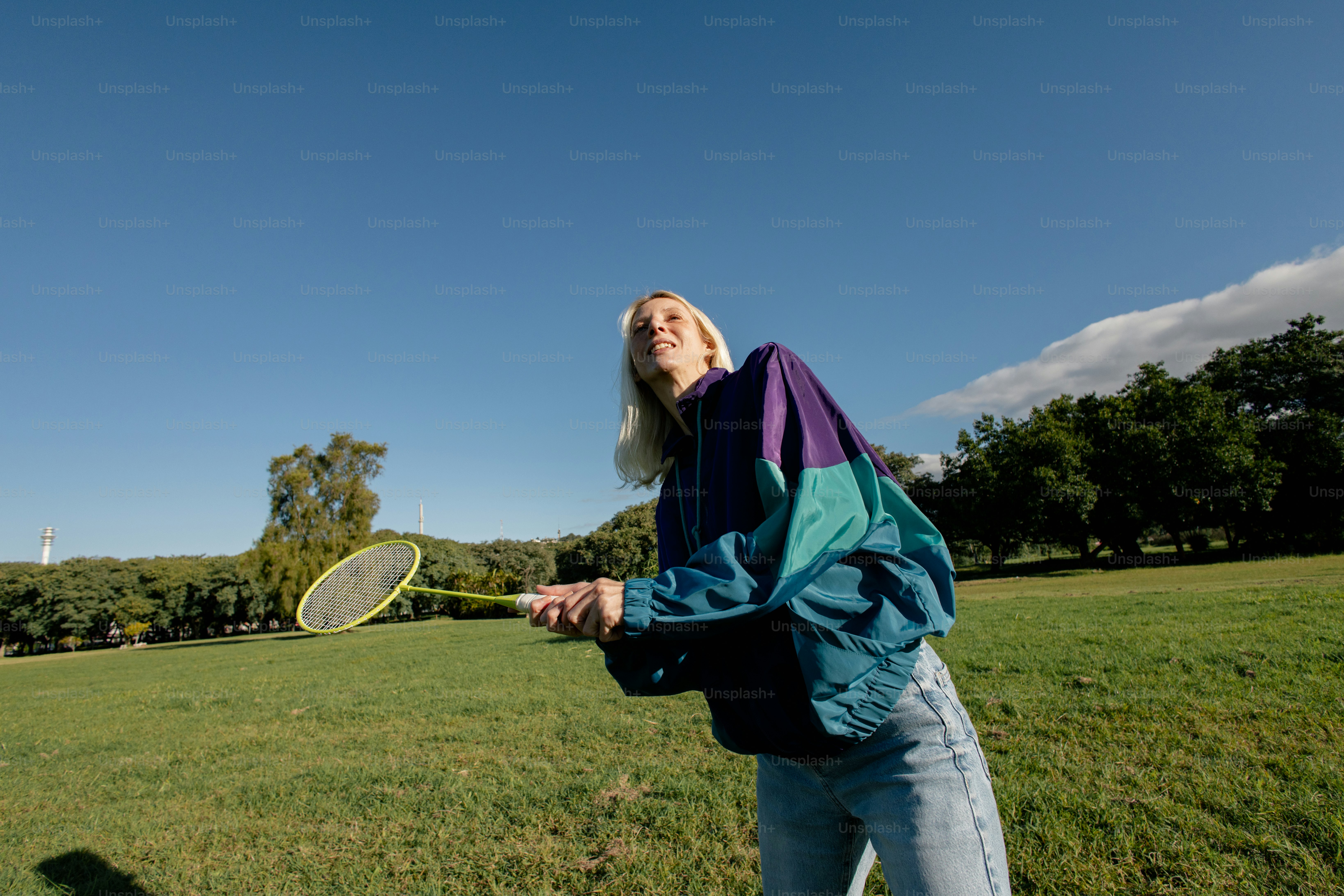Person playing badminton in a sunny park