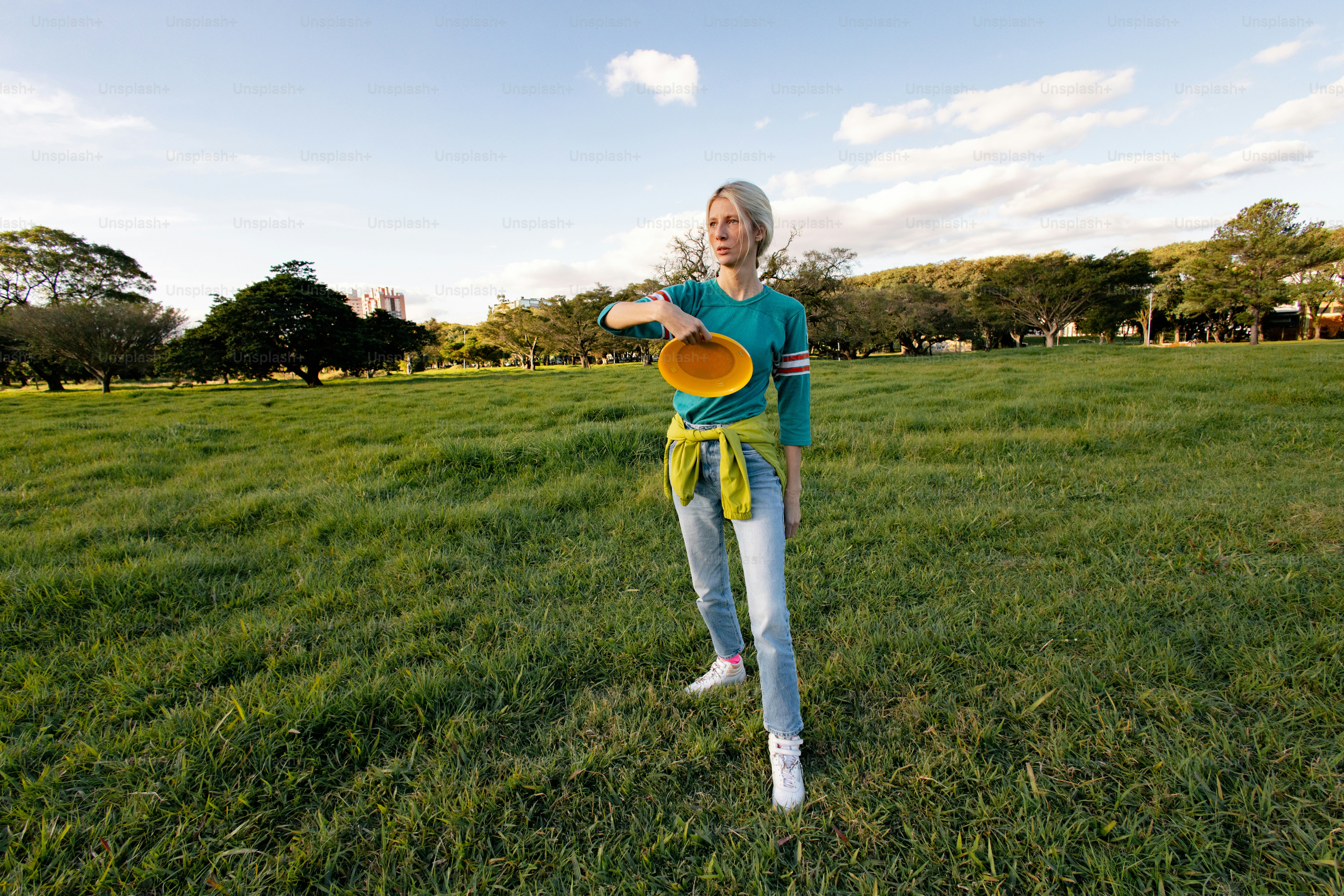 Woman preparing to throw frisbee in grassy field